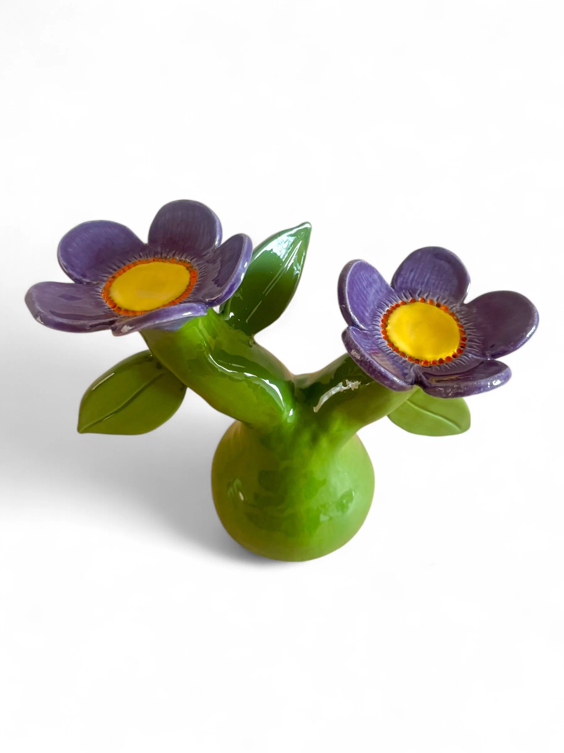 Colorful ceramic vase shaped like a cactus with purple flowers, green leaves, and a round base
