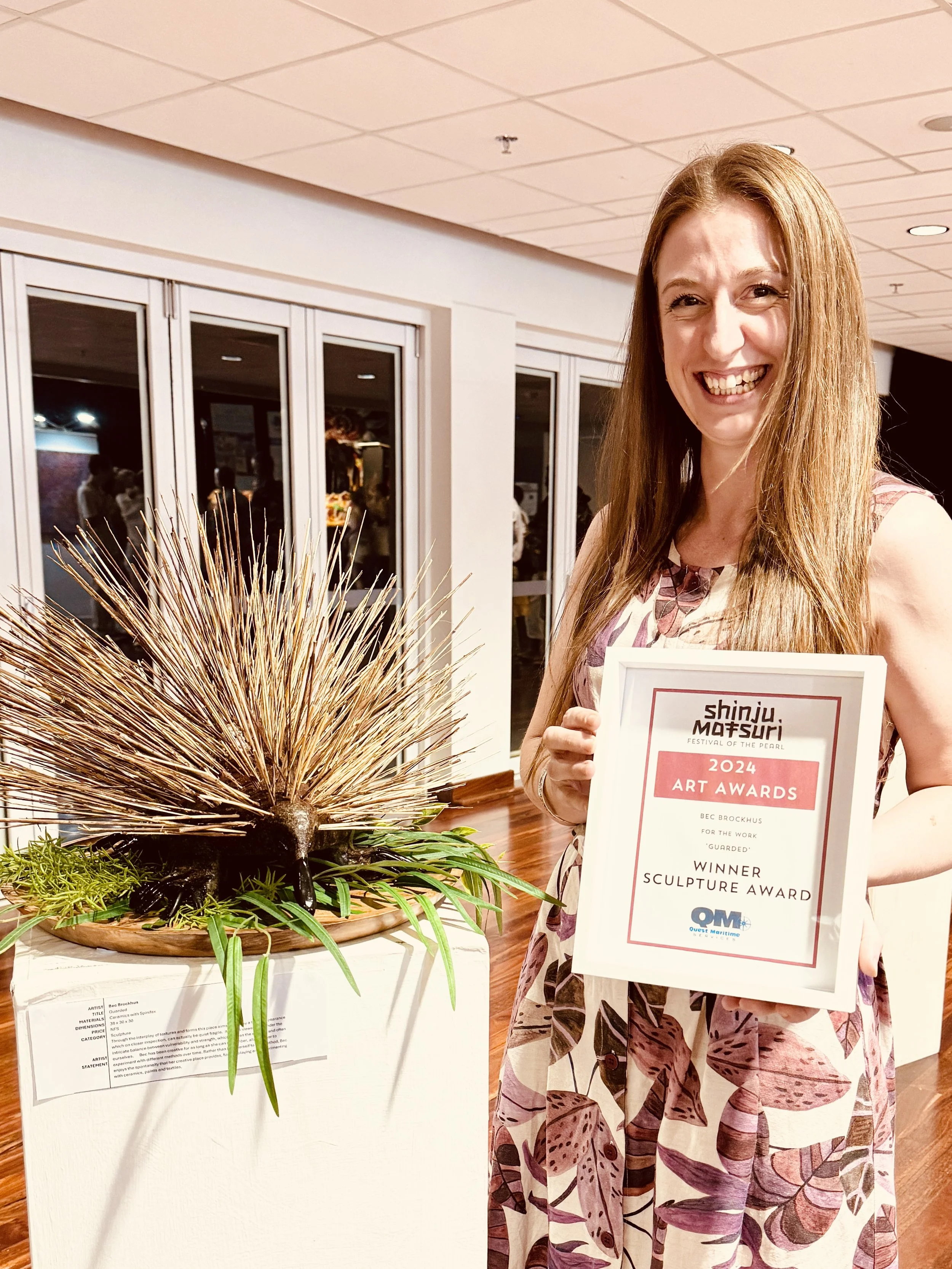 Bec Brockhus from Bec's Creative Place and her Winning Sculpture 'Guarded' at an art exhibition at the Shinju Matsuri 2024 Art Awards. 
