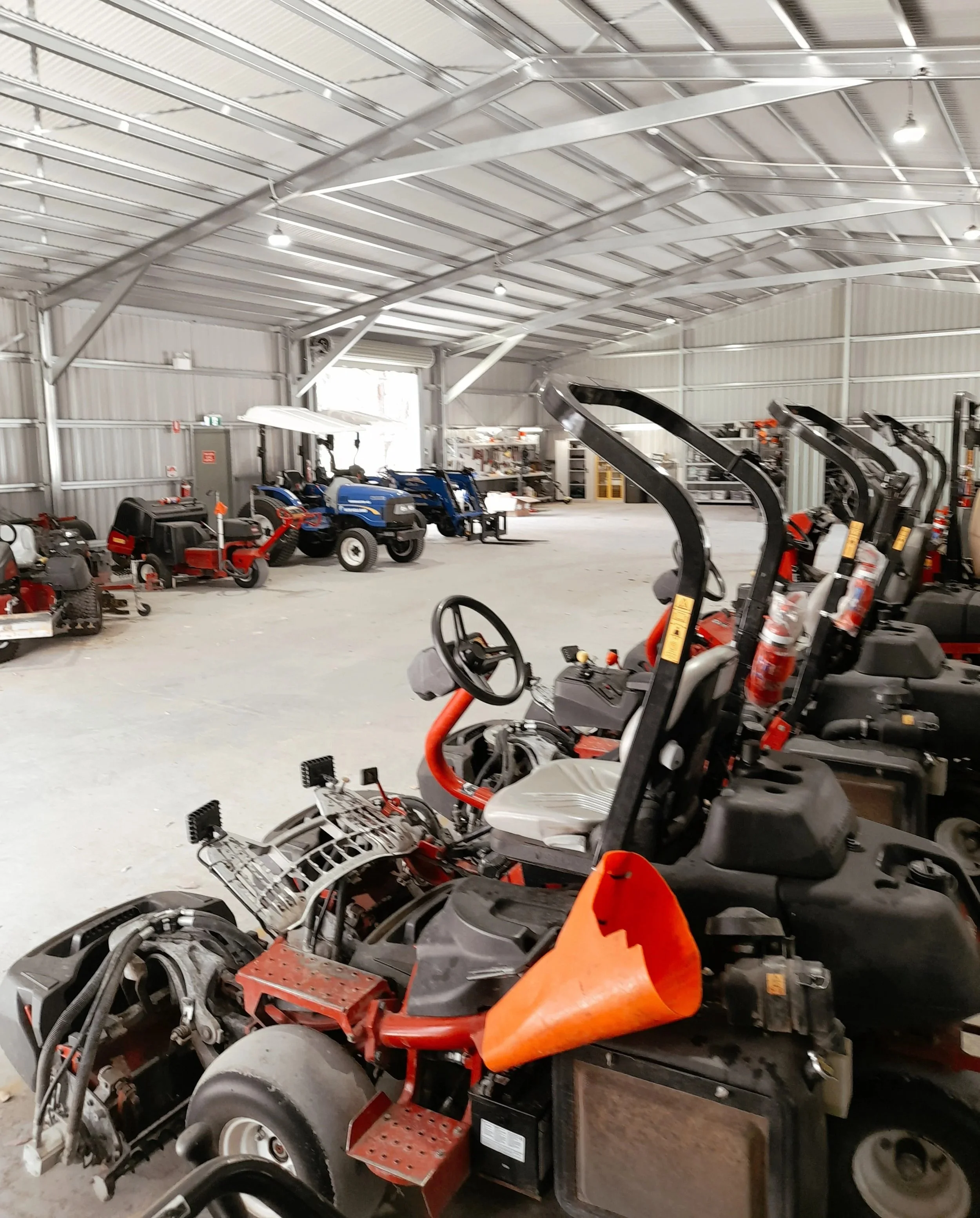Commercial mowers and turf equipment inside Rhodes Mechanical workshop awaiting servicing