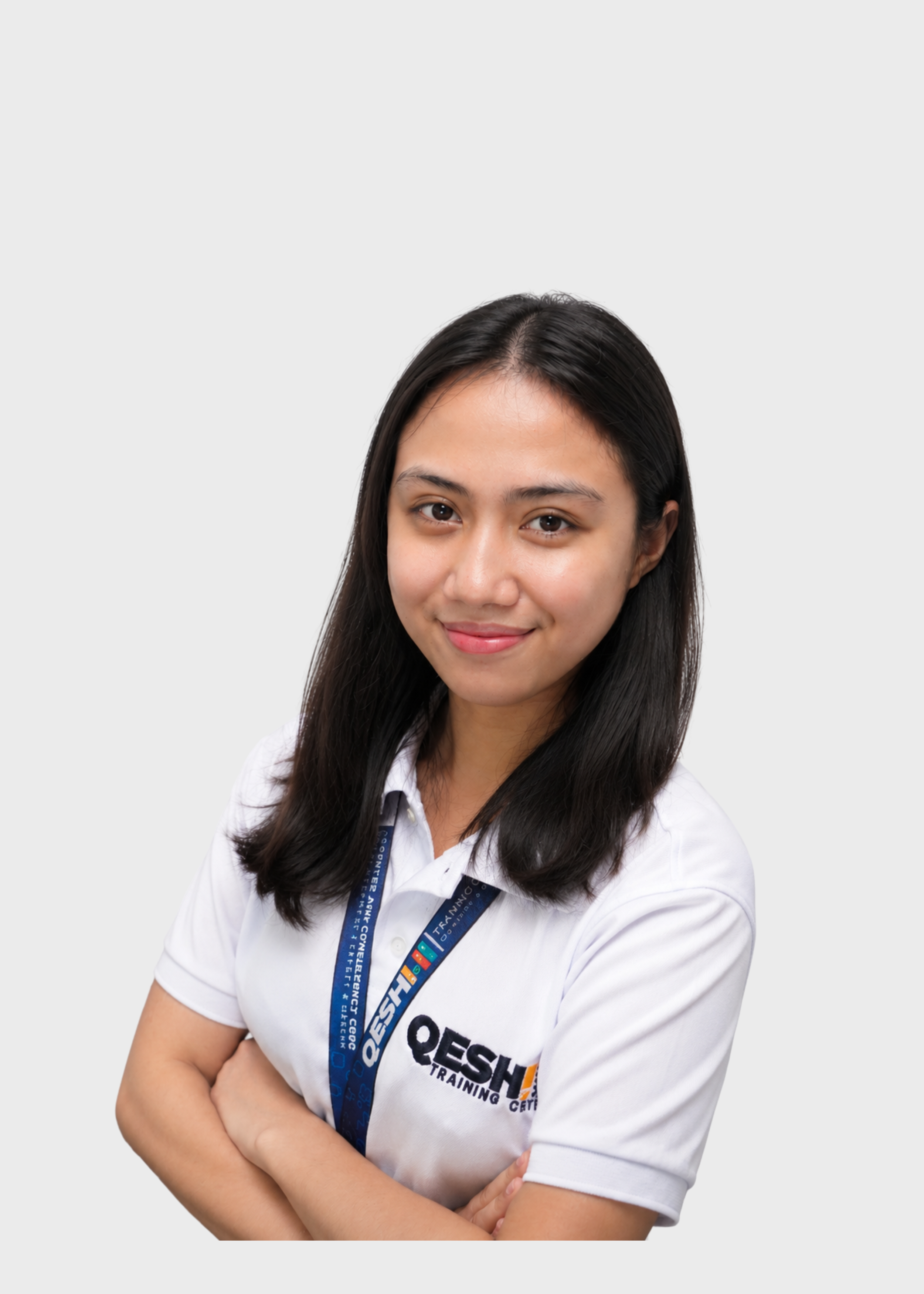 Woman with long black hair, wearing a white polo shirt and a blue lanyard, smiling with arms crossed in front of a plain background.