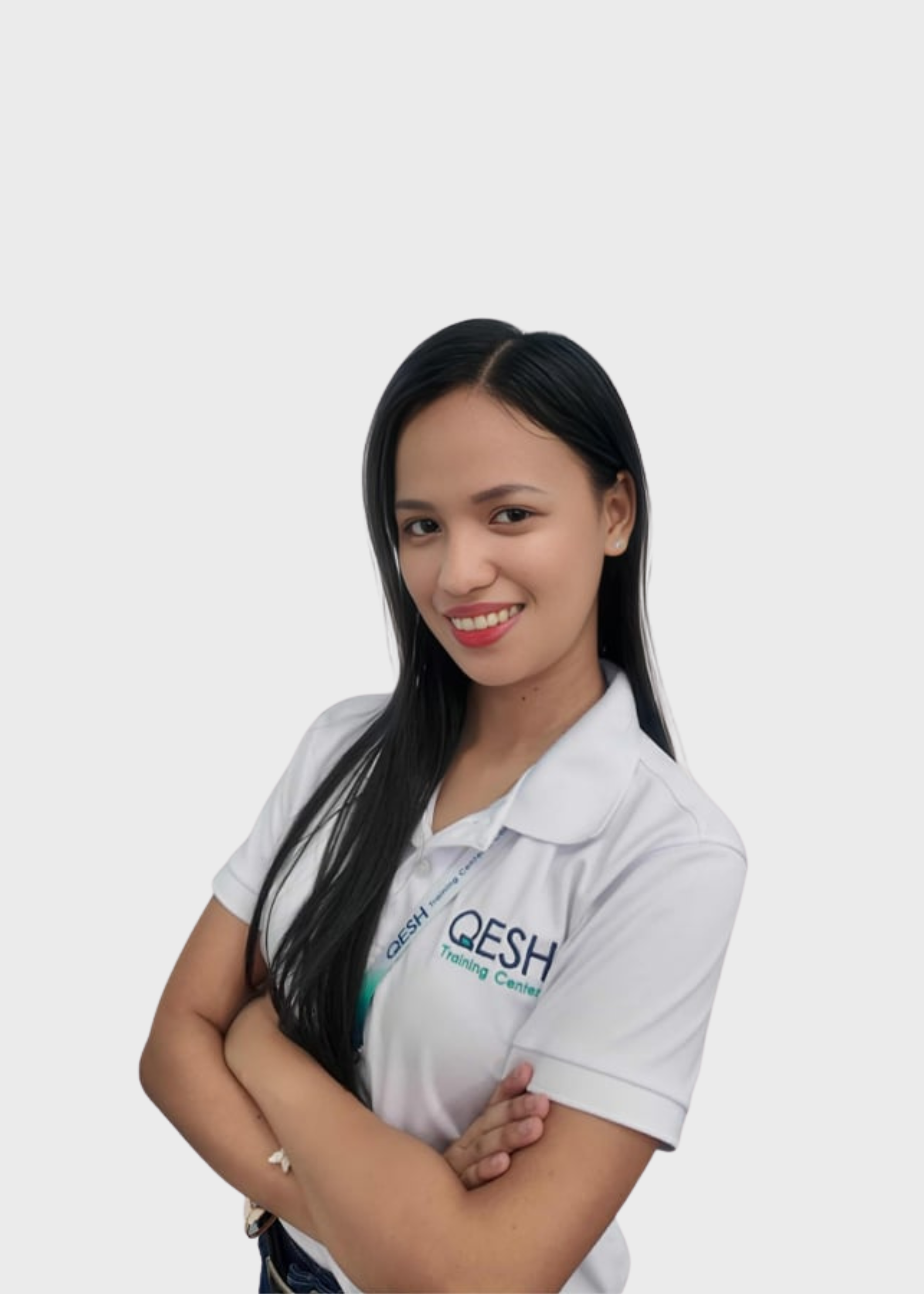 Woman smiling in a white polo shirt with "QESH Training Center" logo, arms crossed, wearing a lanyard.