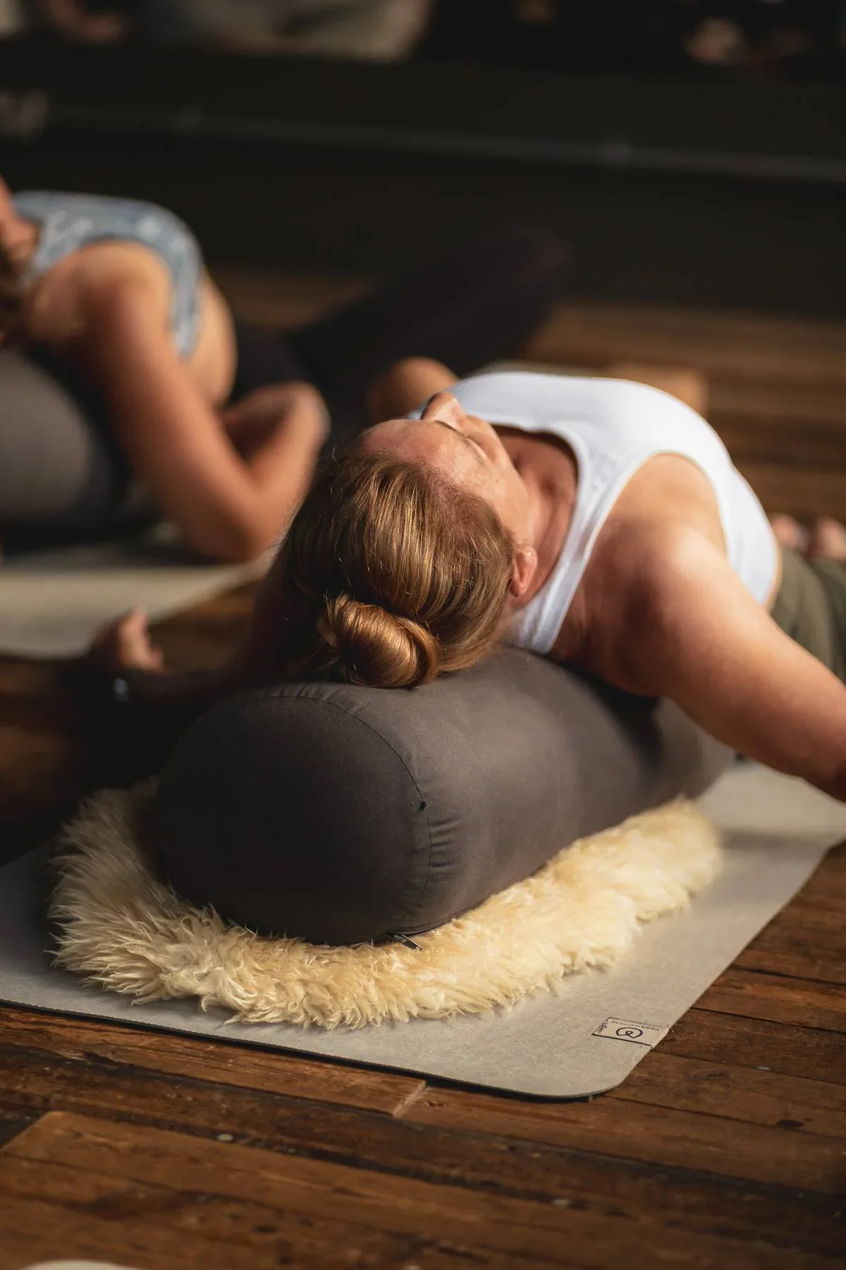 Reclined Yin Yoga posture supported with bolsters and blankets, encouraging deep relaxation and nervous system regulation.