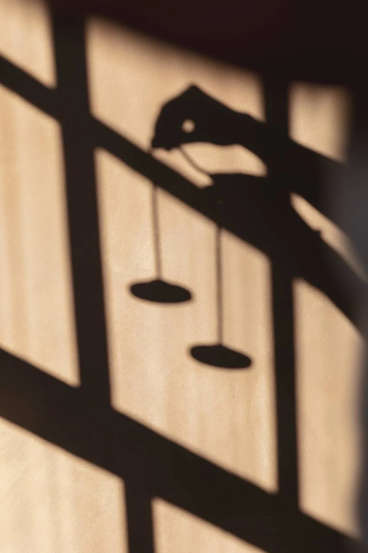 Hanging meditation chimes casting shadows during a Sound Healing session at Heist House Studios in Warwick