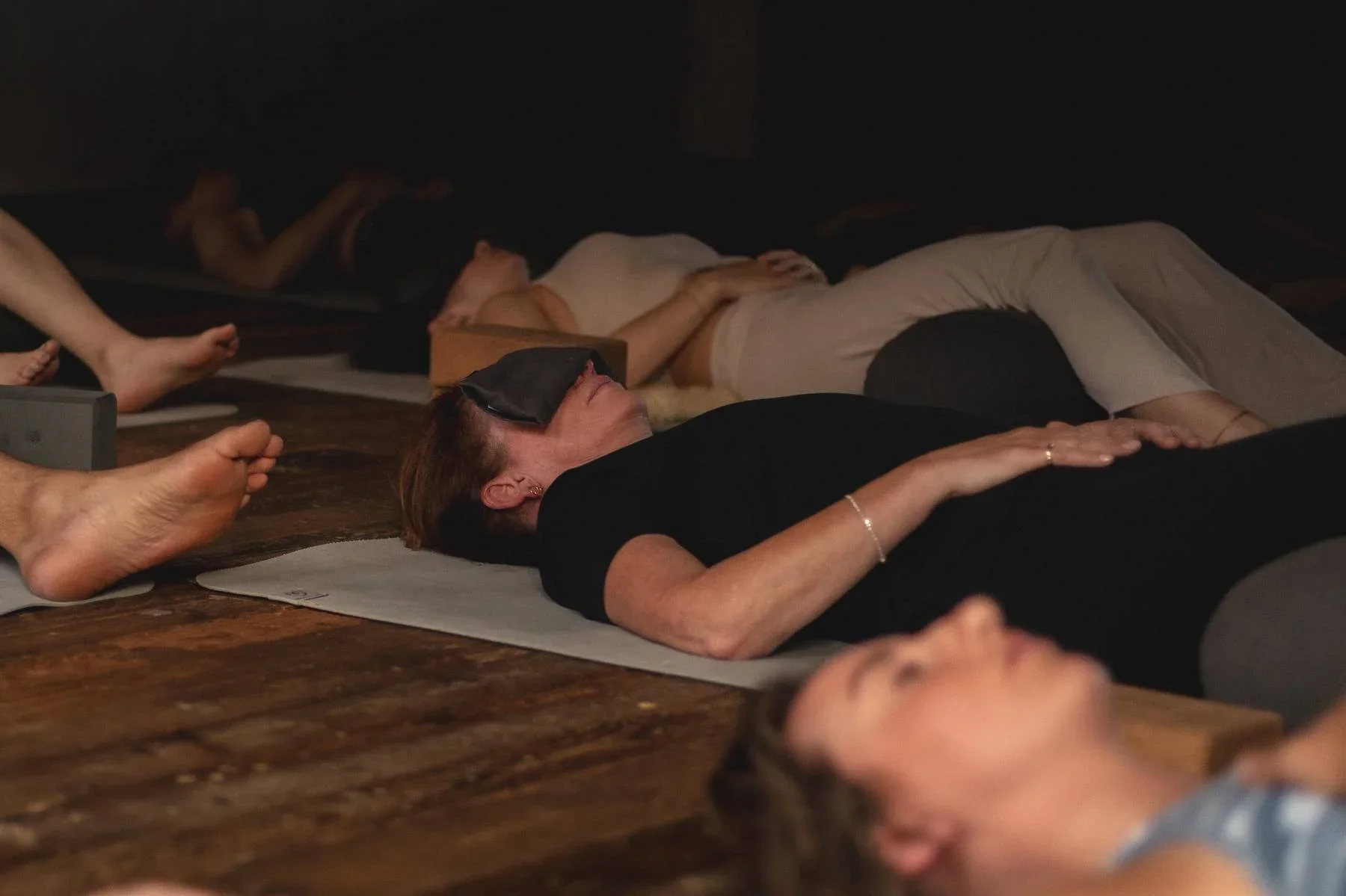 Students resting during a Sound Healing session at Heist House Studios in Warwick, wearing eye pillows during guided relaxation.