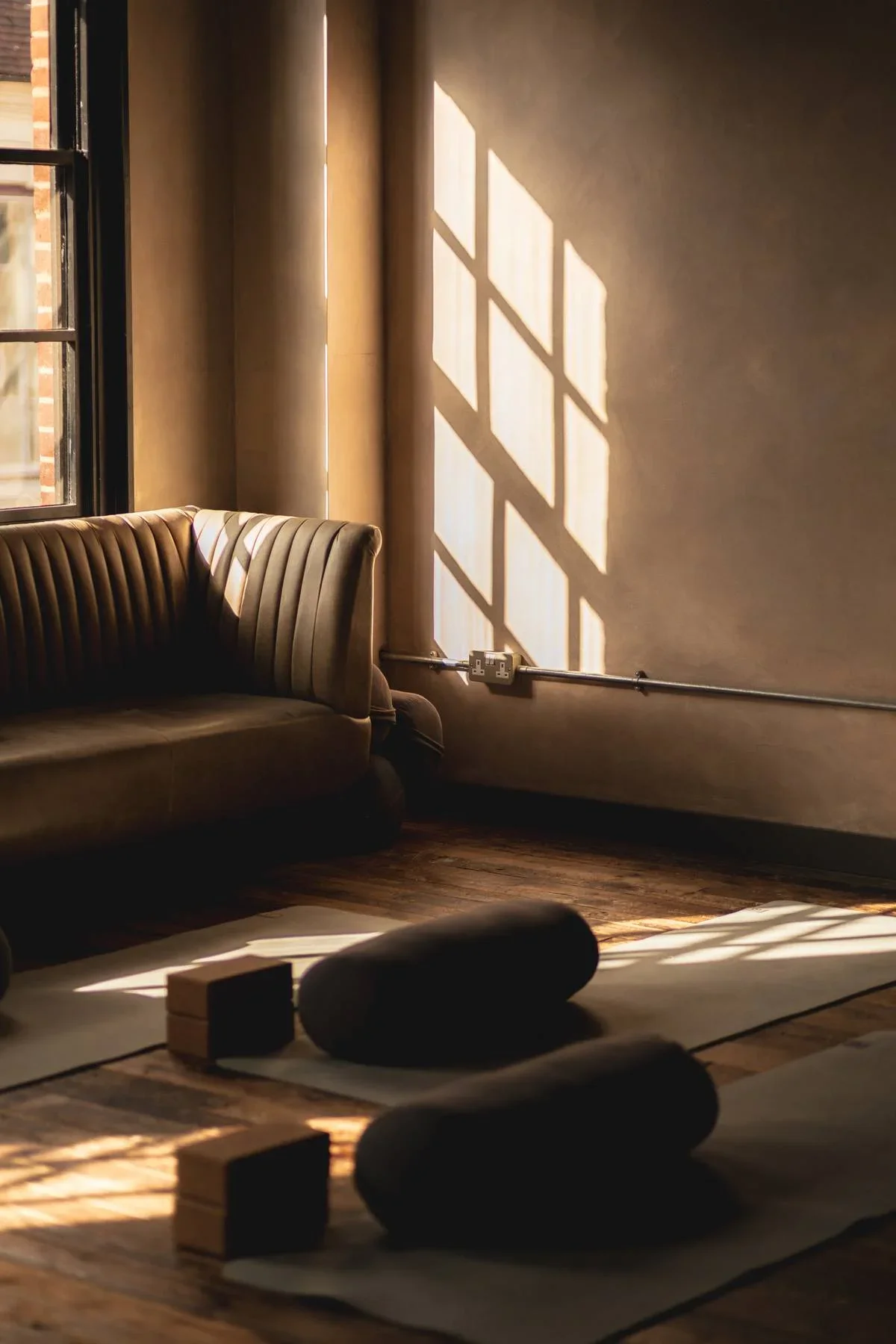 Calm restorative yoga space at Heist House Studios in Warwick with soft natural light and quiet seating area designed for relaxation.