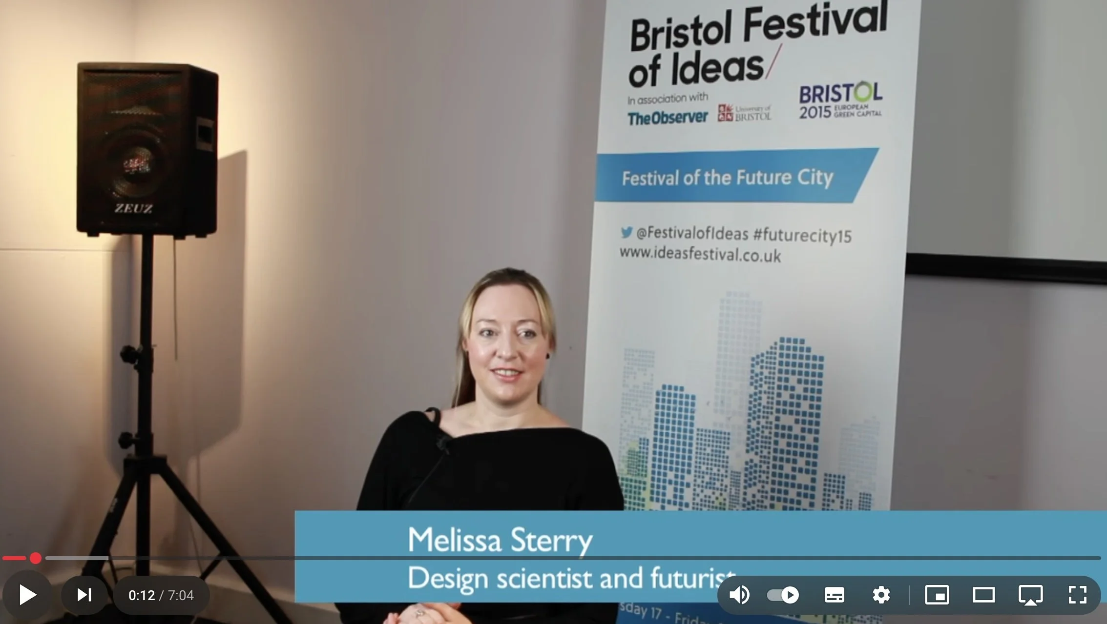 Dr. Melissa Sterry speaking at Bristol Festival of Ideas 2015 with event banner and speaker in background.