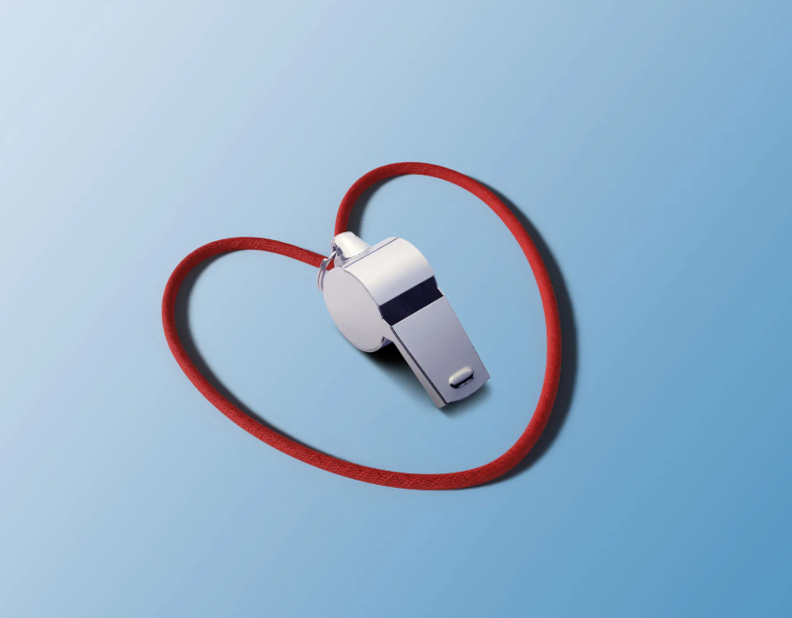 silver whistle surrounded by it's red heart string 