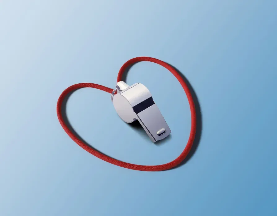 silver whistle surrounded by it's red heart string