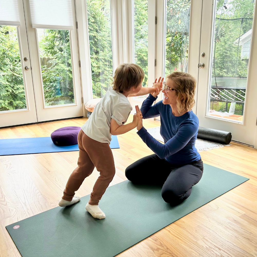 Caroline Gebhardt supporting a child through a developmentally informed somatic movement exercise.