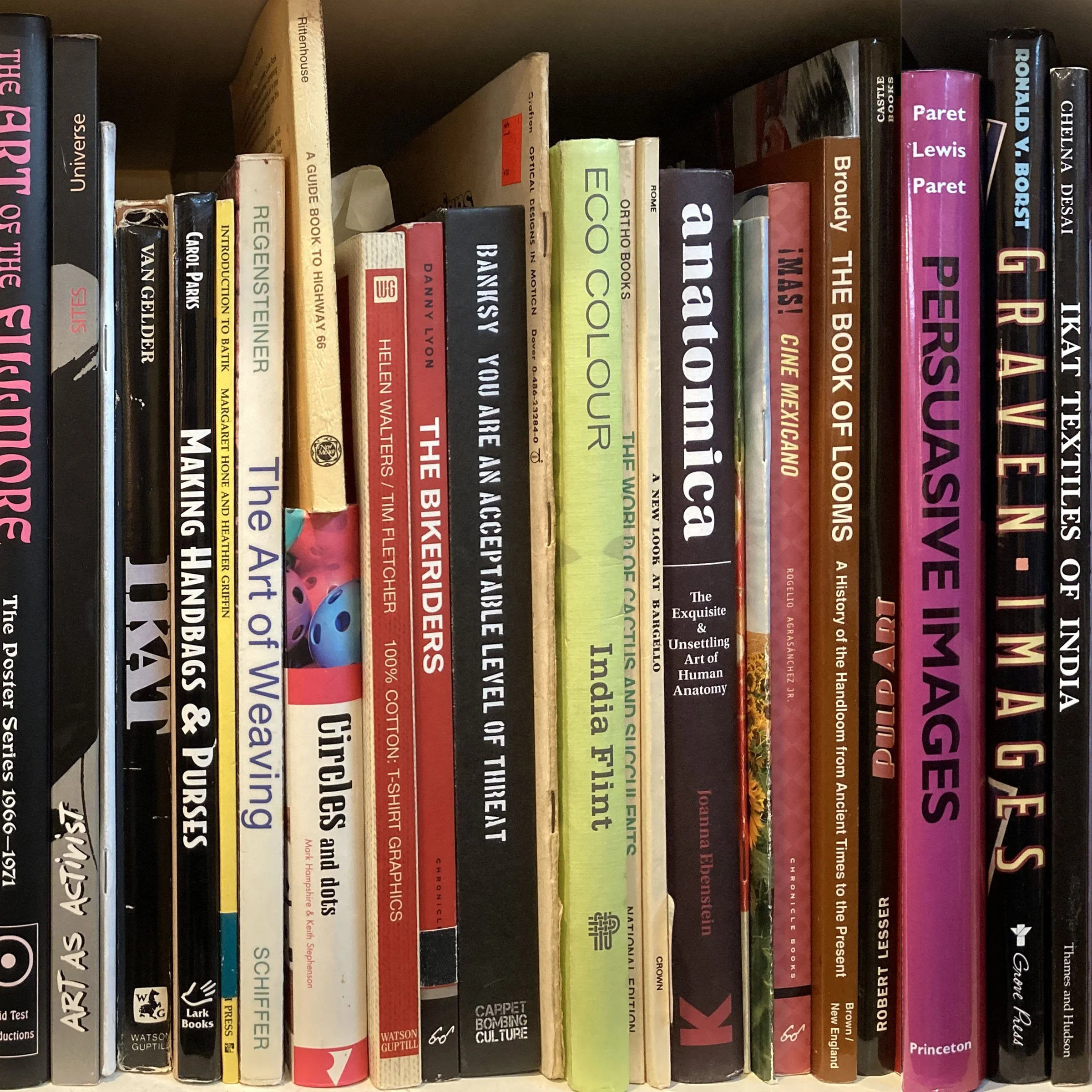 A bookshelf filled with various books of different sizes and colors, arranged vertically.
