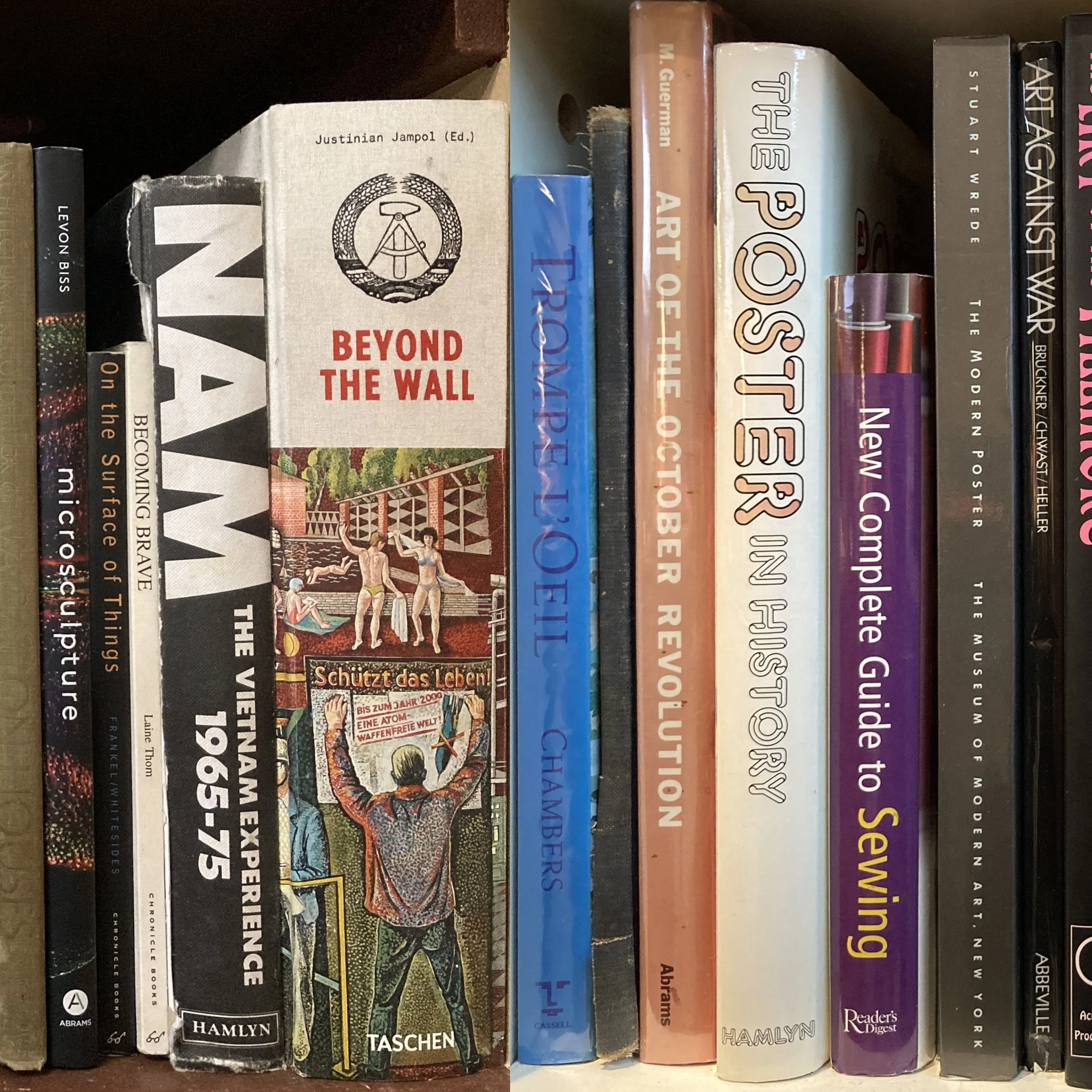 A bookshelf with various books in different sizes and colors, including titles like "Beyond the Wall," "Blue Planet," and "The Art of War." The books are arranged vertically on the shelf.