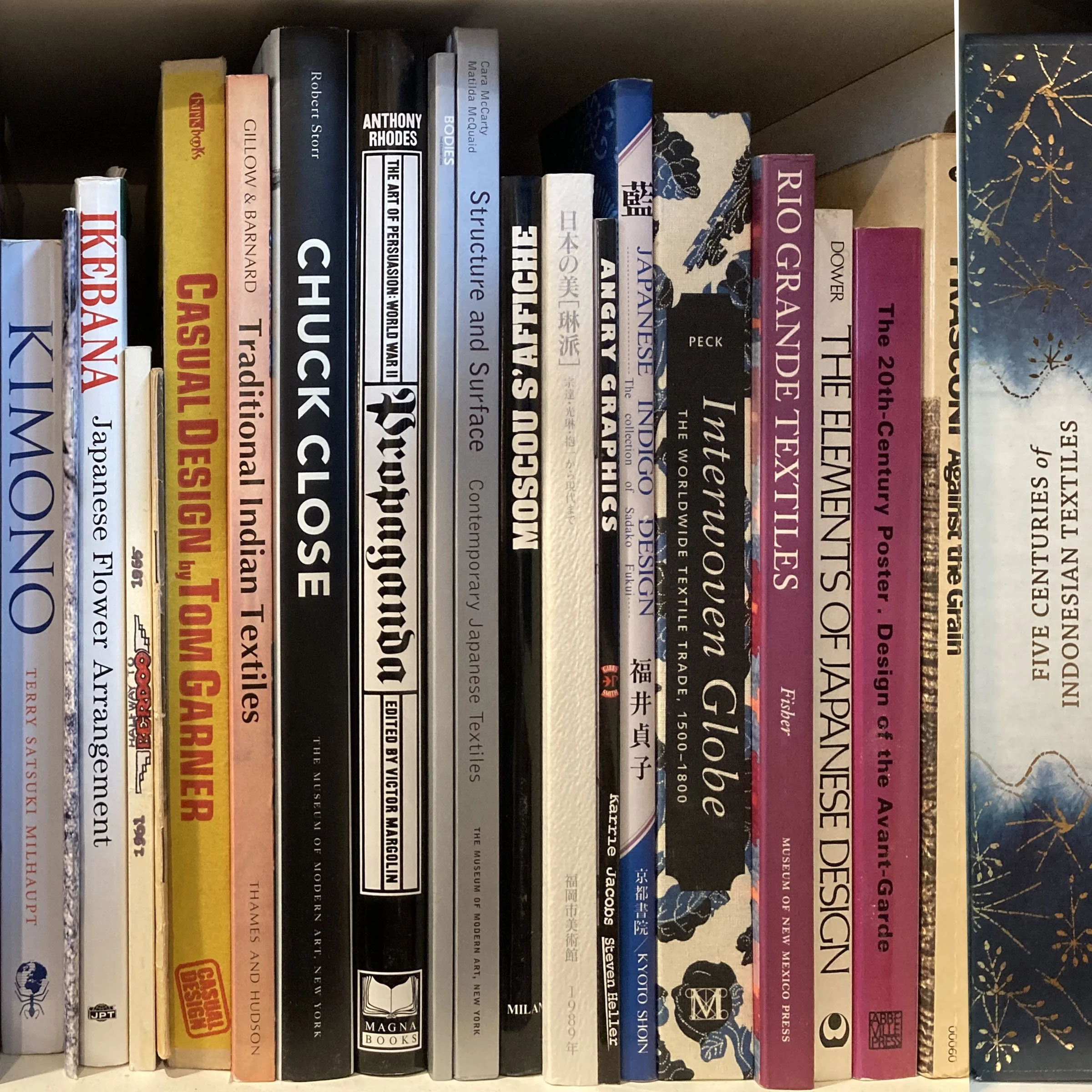 A photo showing a row of books on a shelf, with titles related to art, history, and culture, including works on the art of persuasion, Giotto, and Japanese culture.