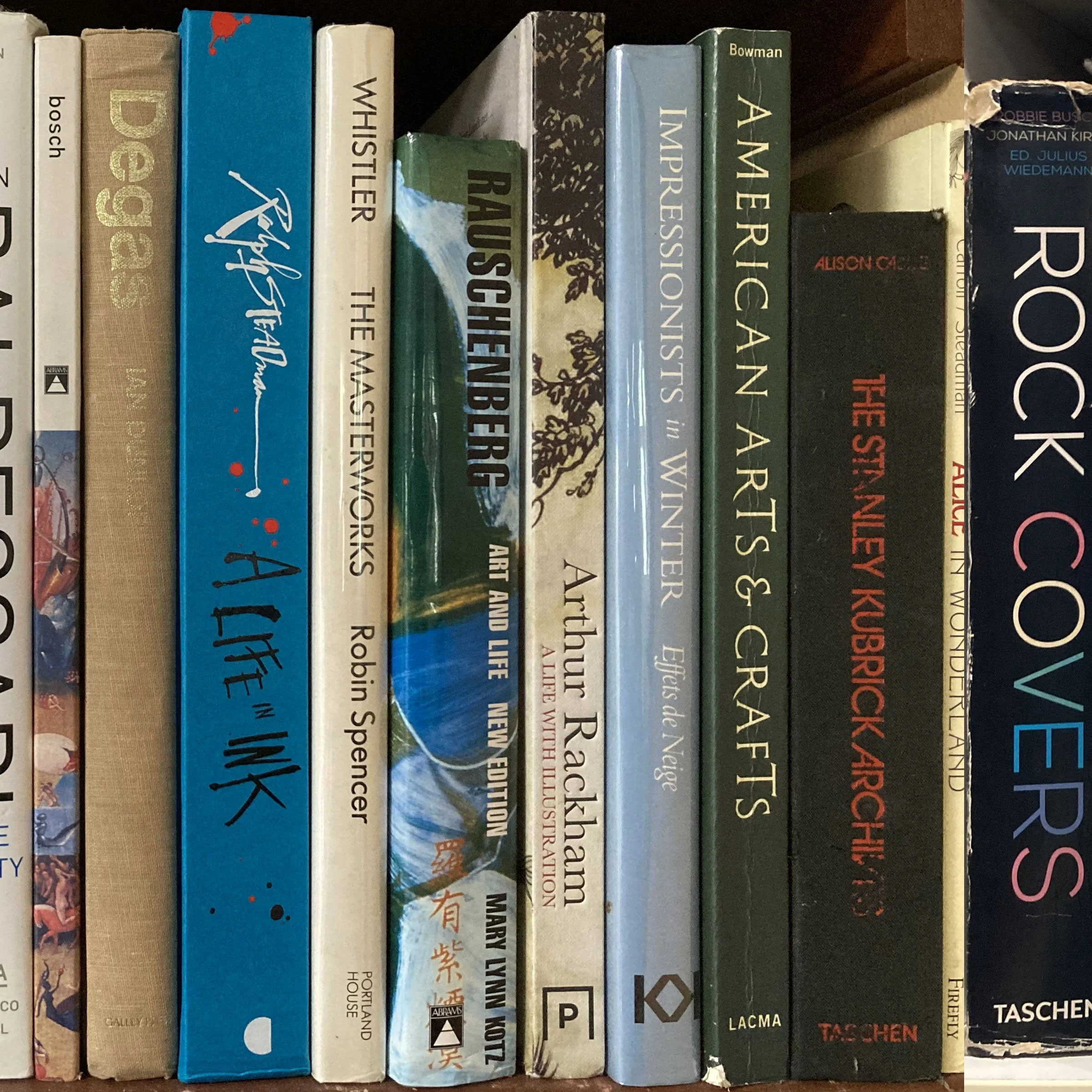 A shelf of assorted books with a variety of colors, titles, and authors, some with visible wear and tear.