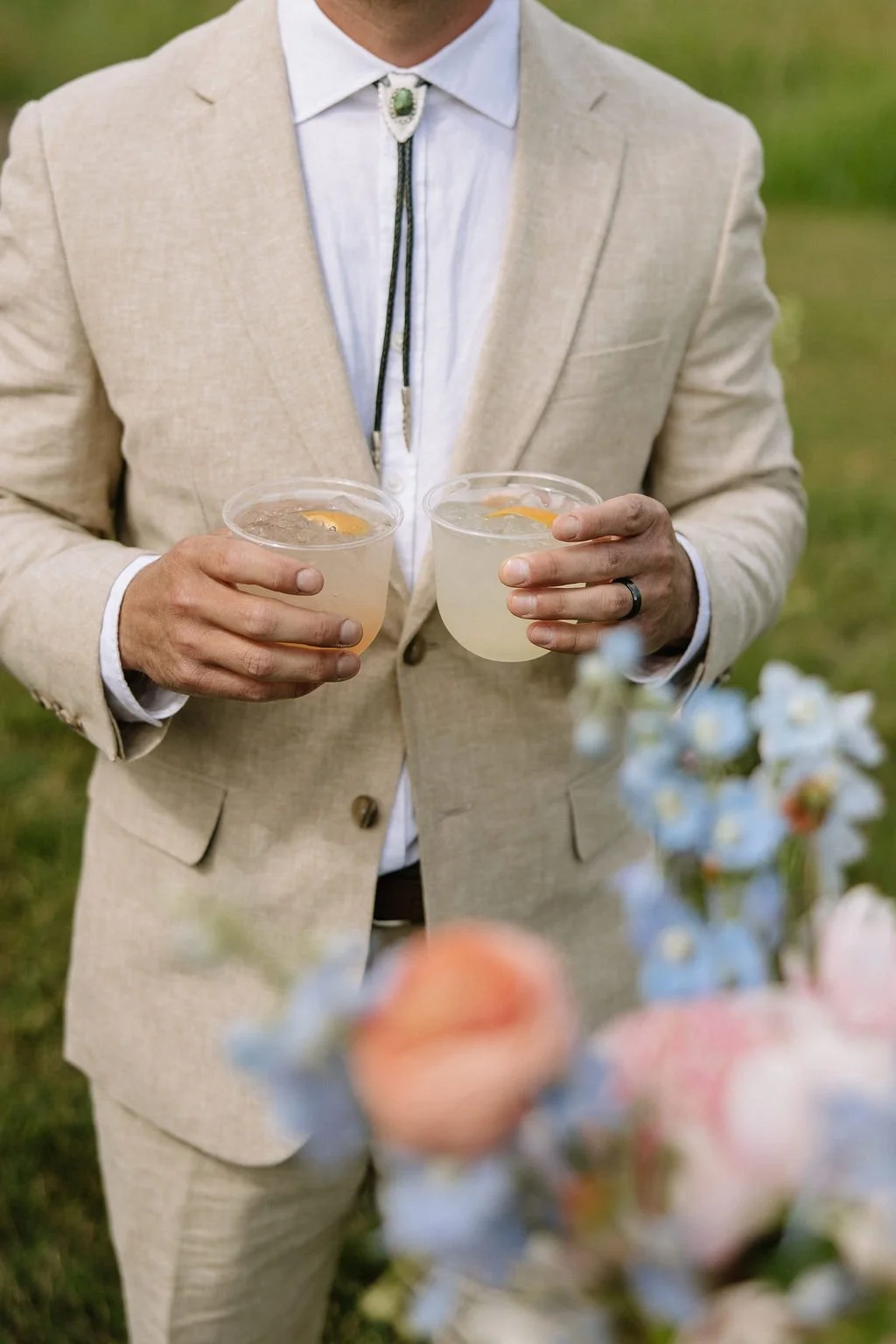 Groom holding two cocktails