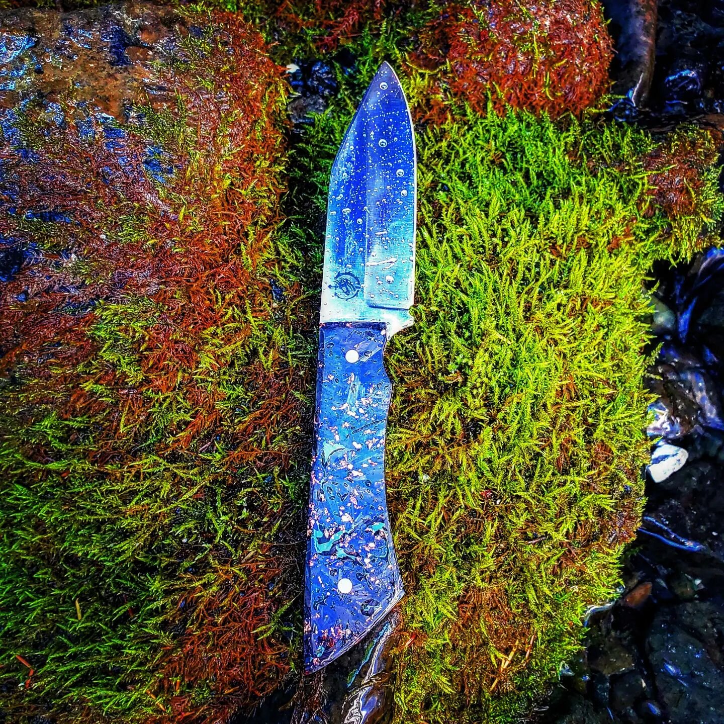Camper in 52100 with carbon fiber scales and red G10 spacers. I'll have better pictures some other time. Out in the woods testing this out.

It will come with a black and red kydex sheath. Up on the website in a few days, or message me now for detail