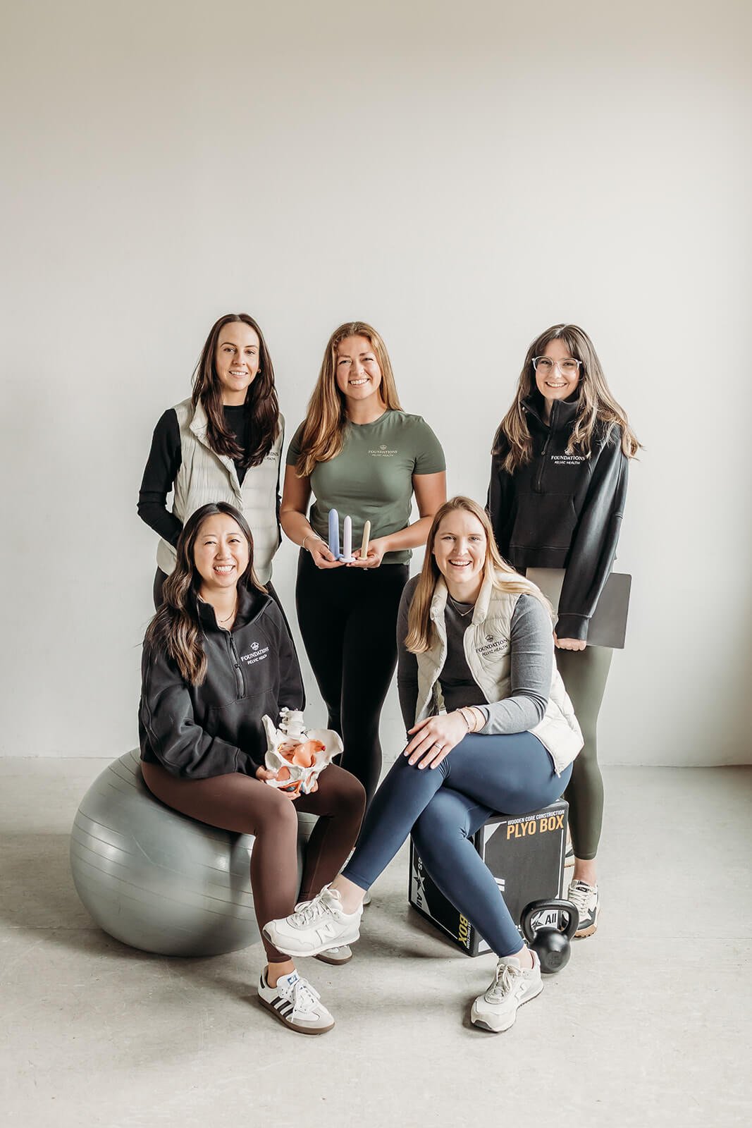 The Foundations Pelvic Health team smiles at the camera with their pt accessories in Boston.