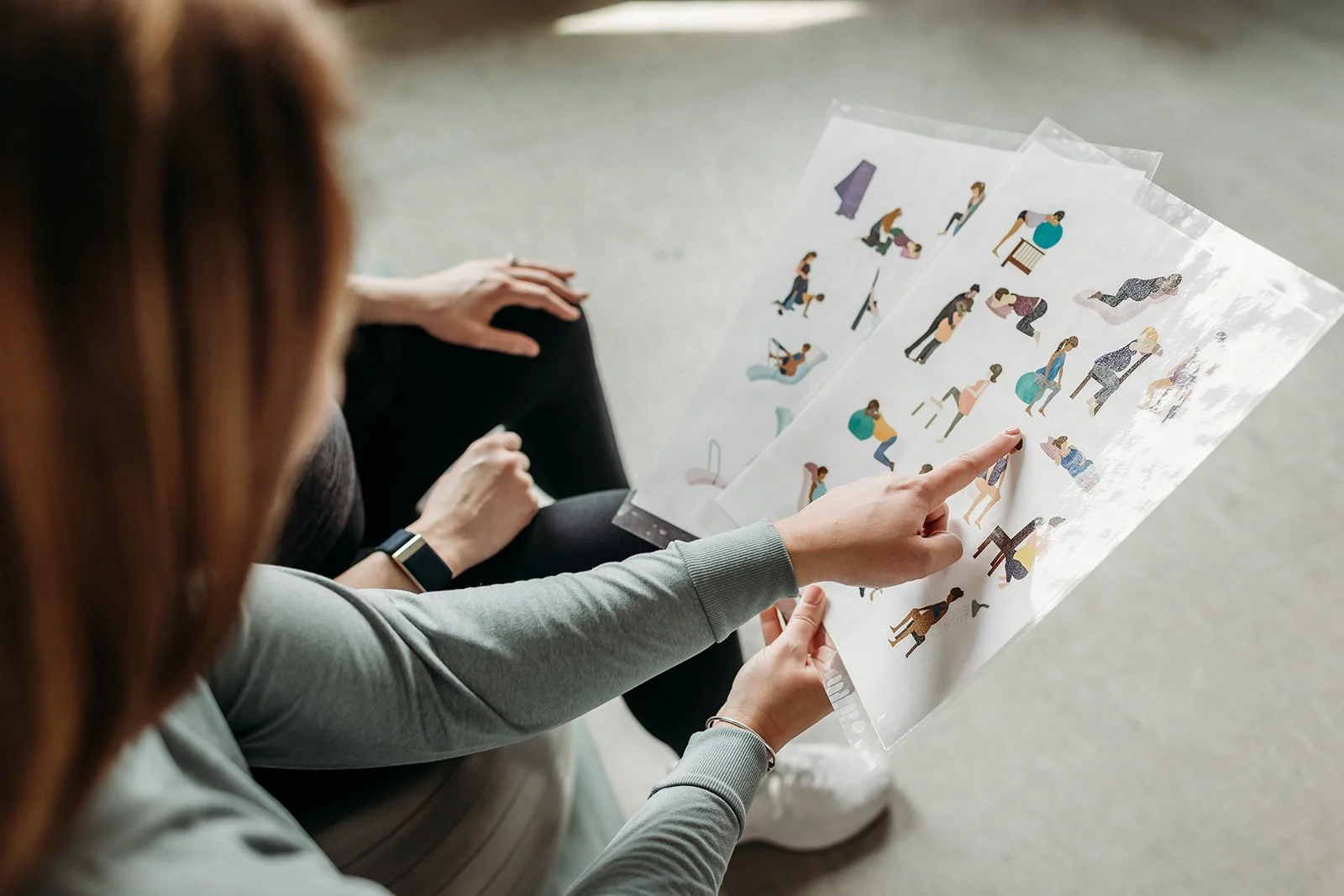 A Foundations Pelvic Health physical therapist reviews labor and delivery positions with her pregnant client during a physical therapy birth prep session..