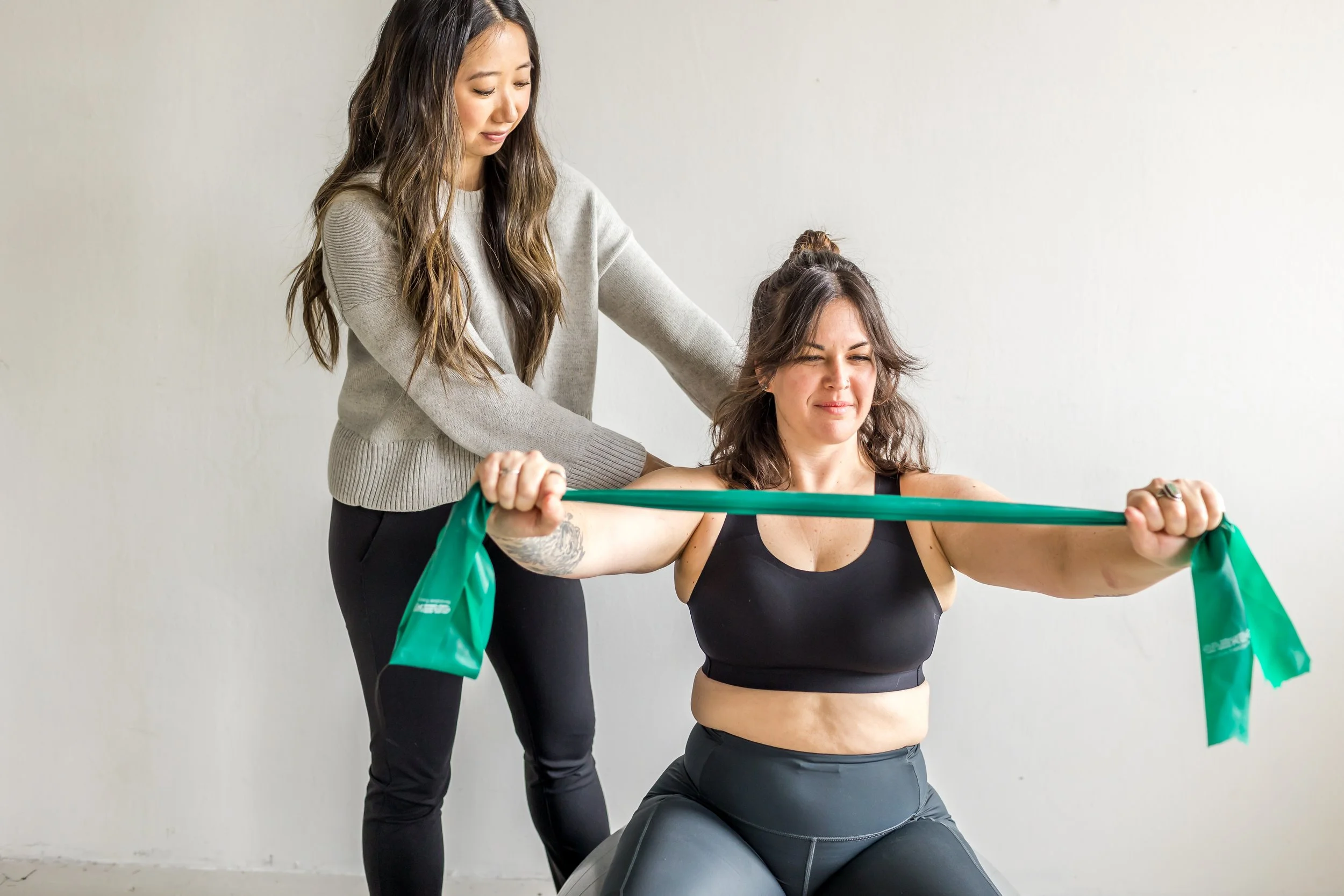 Postpartum woman doing her postural strengthening exercises with her pelvic floor specialist Donna Chiao to relieve mommy thumb pain.