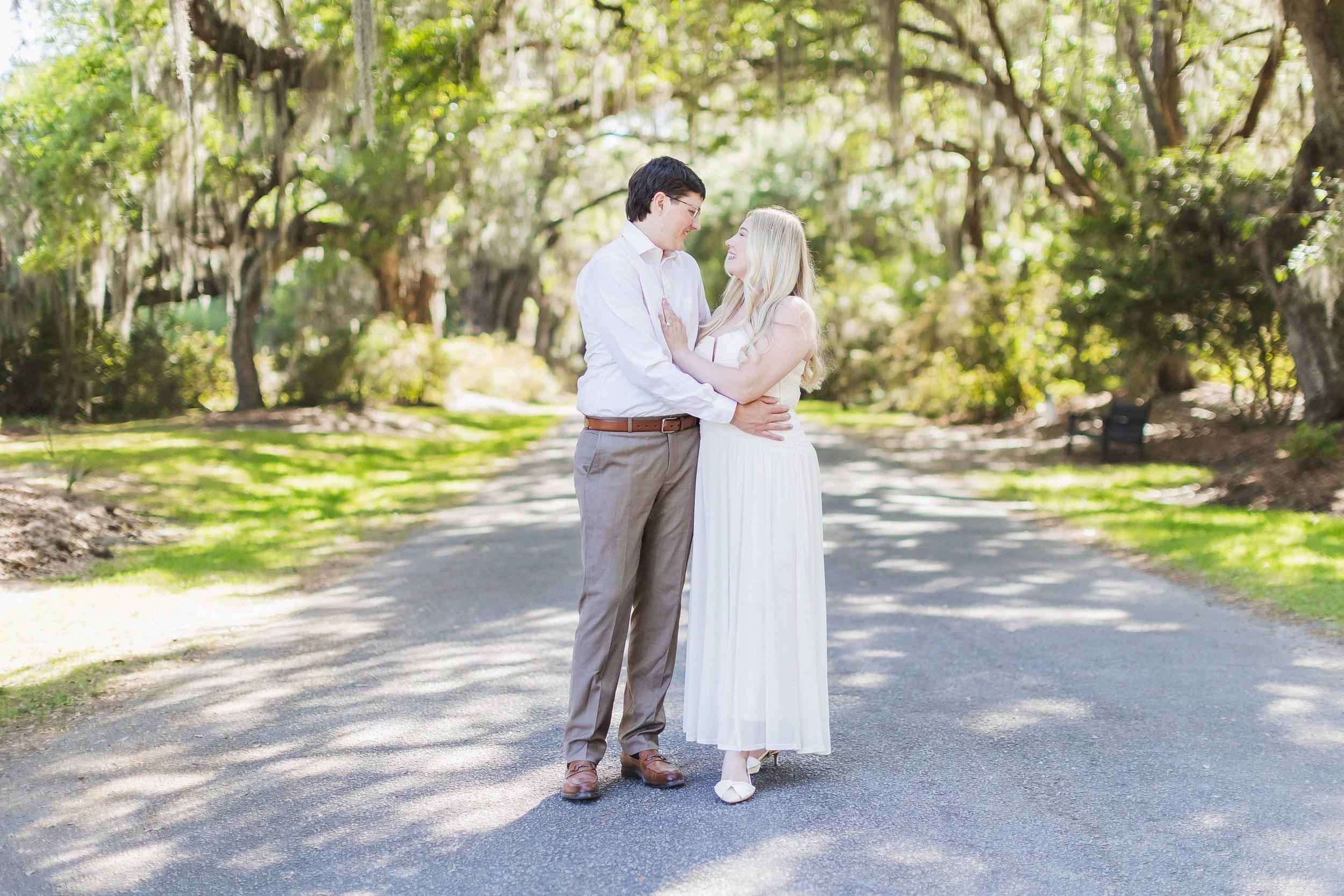 Engaged couple embracing beneath live oaks at Magnolia Plantation, Charleston