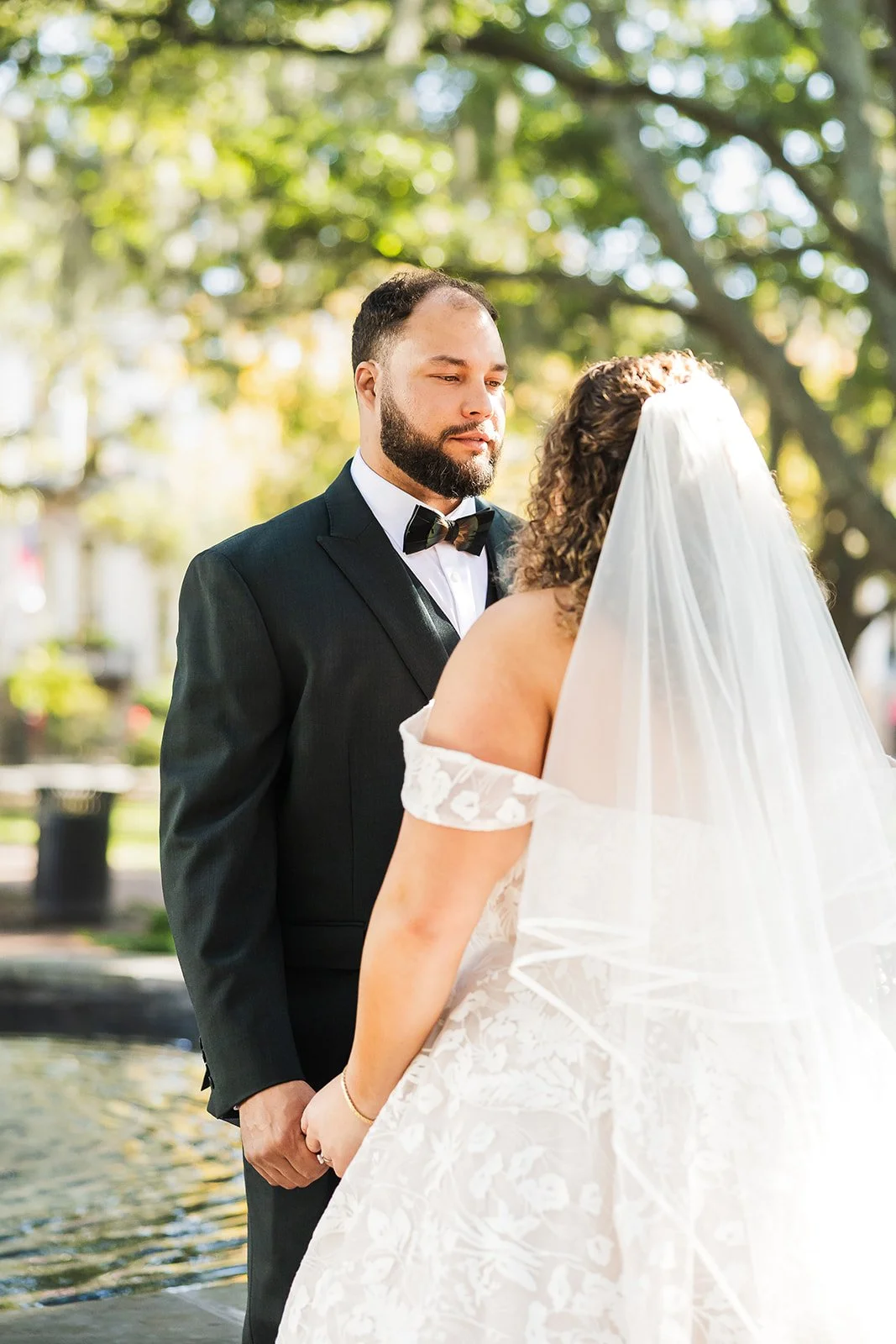 Groom and veiled bride under an oak canopy in Savannah's historic district