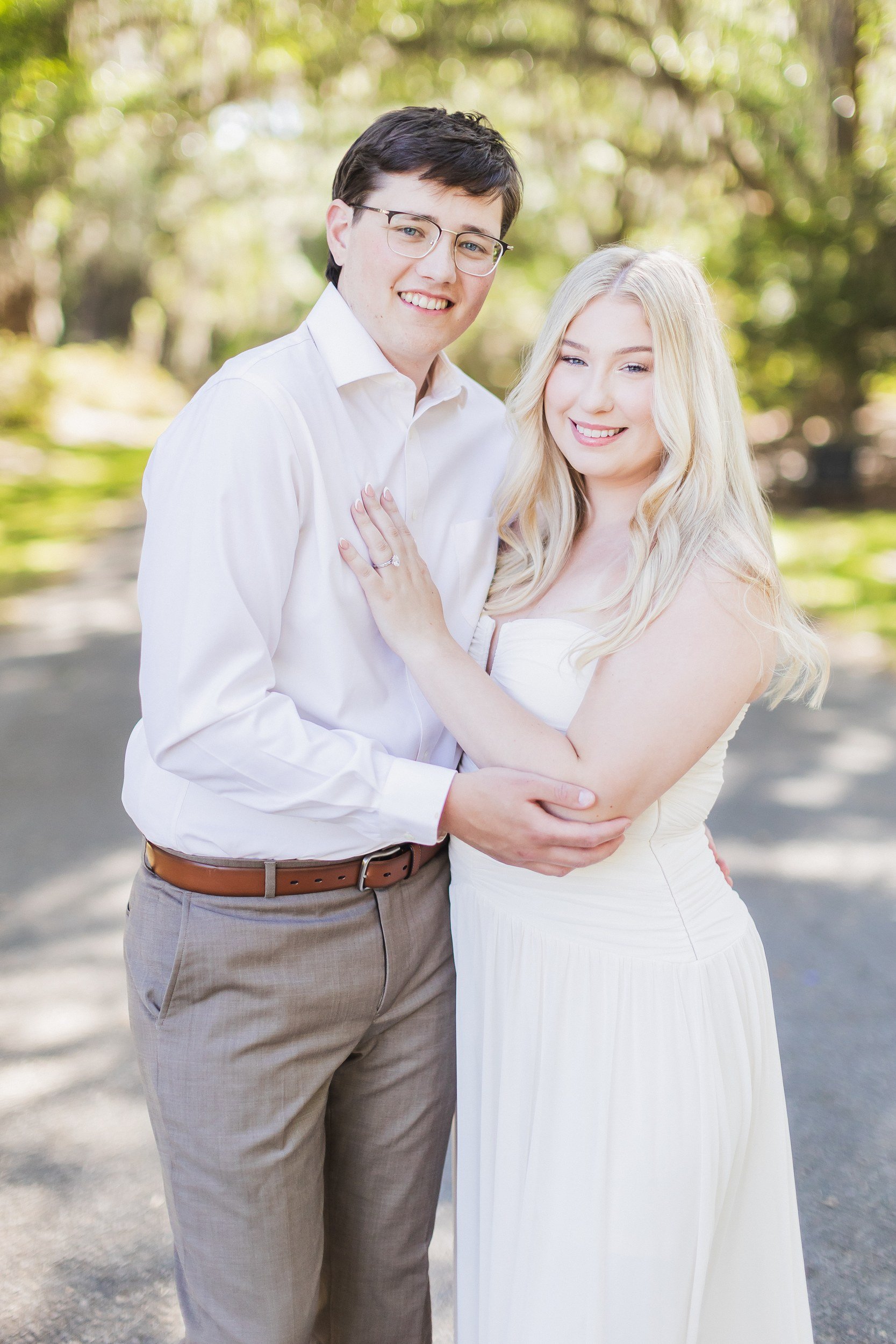 Smiling engaged couple on the oak-lined avenue at Magnolia Plantation, Charleston