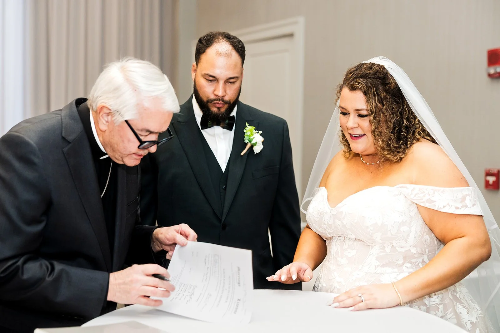 Bride and groom sign their marriage documents with the officiant