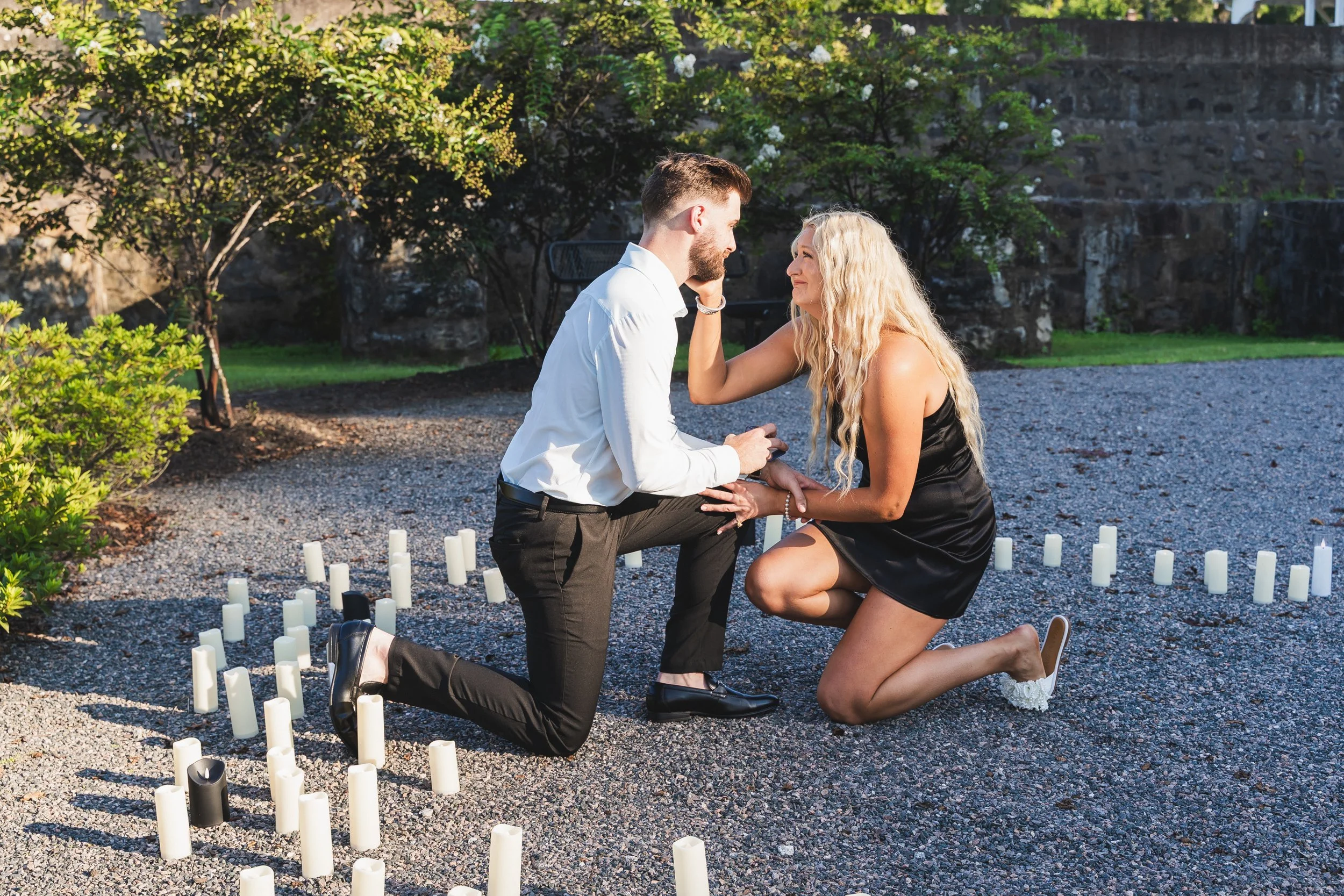 Surprise proposal among candles in a garden