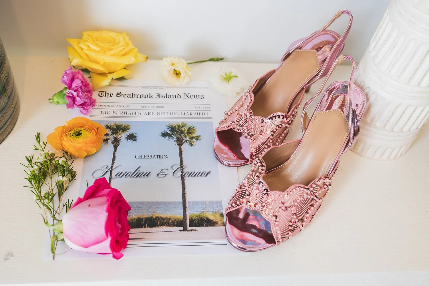 Pink sparkly heels, bright flowers and an invitation styled as a newspaper called The Seabrook Island News, celebrating Karolina and Connor, at Seabrook Island Club on Seabrook Island, South Carolina.
