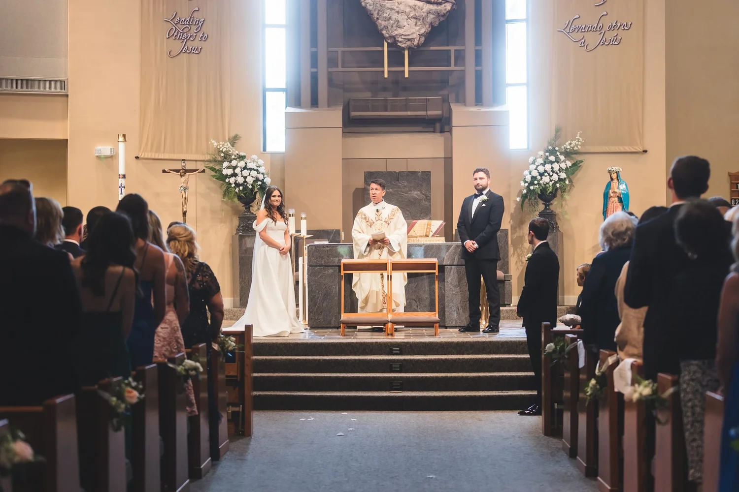 Madison and Derek at the altar during their ceremony at Saint Mary Magdalene Catholic Church in Simpsonville, South Carolina.