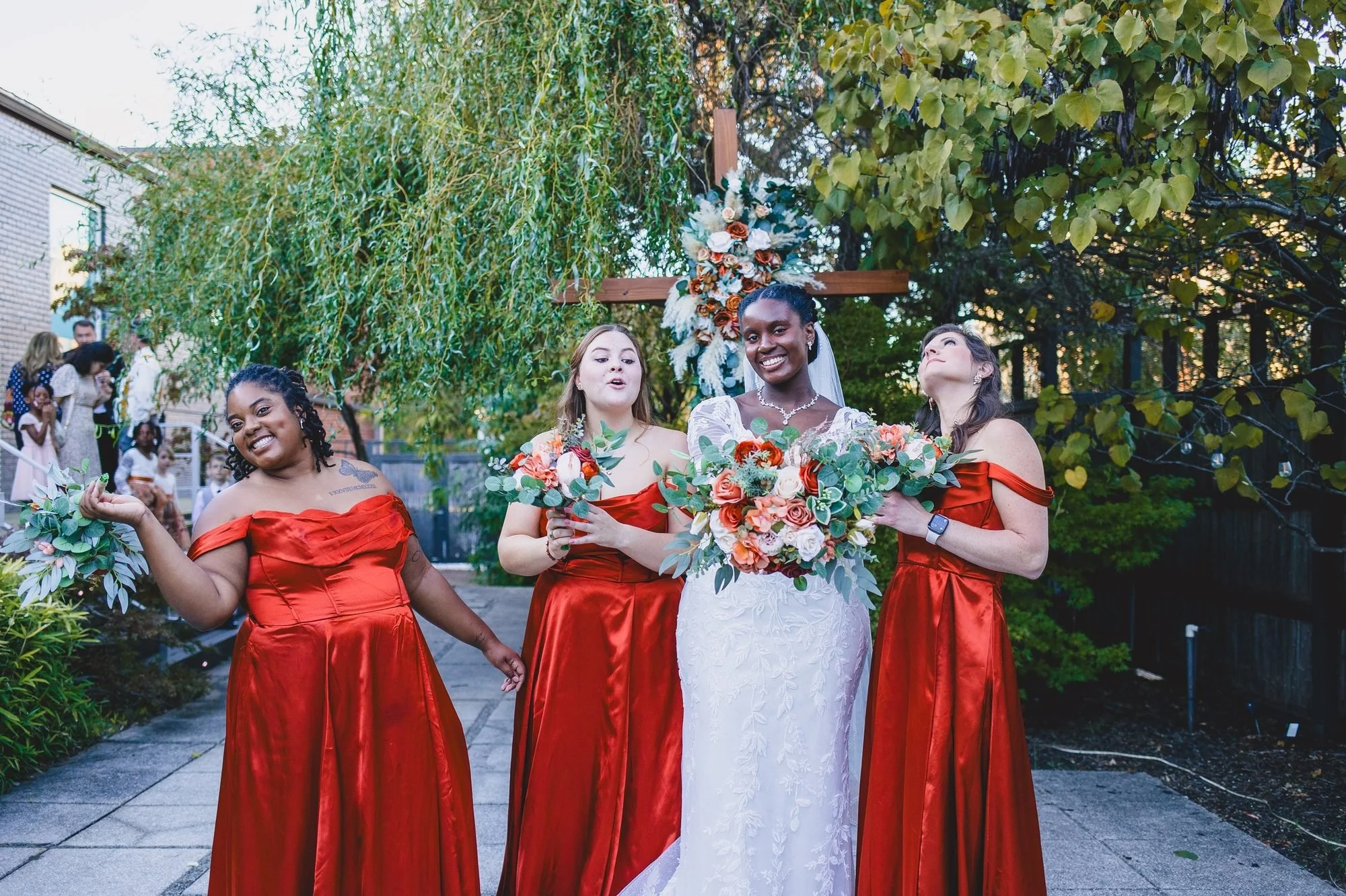 Bride with bridesmaids in rust gowns at a fall wedding
