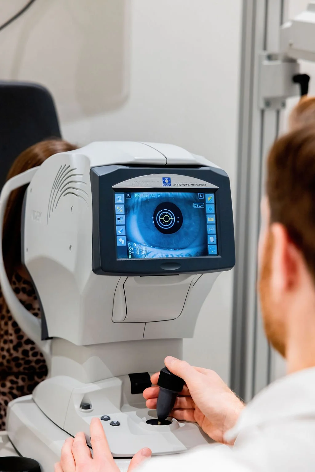 Optometrist performing optometry eye exams and eye tests using latest technology and equipment
