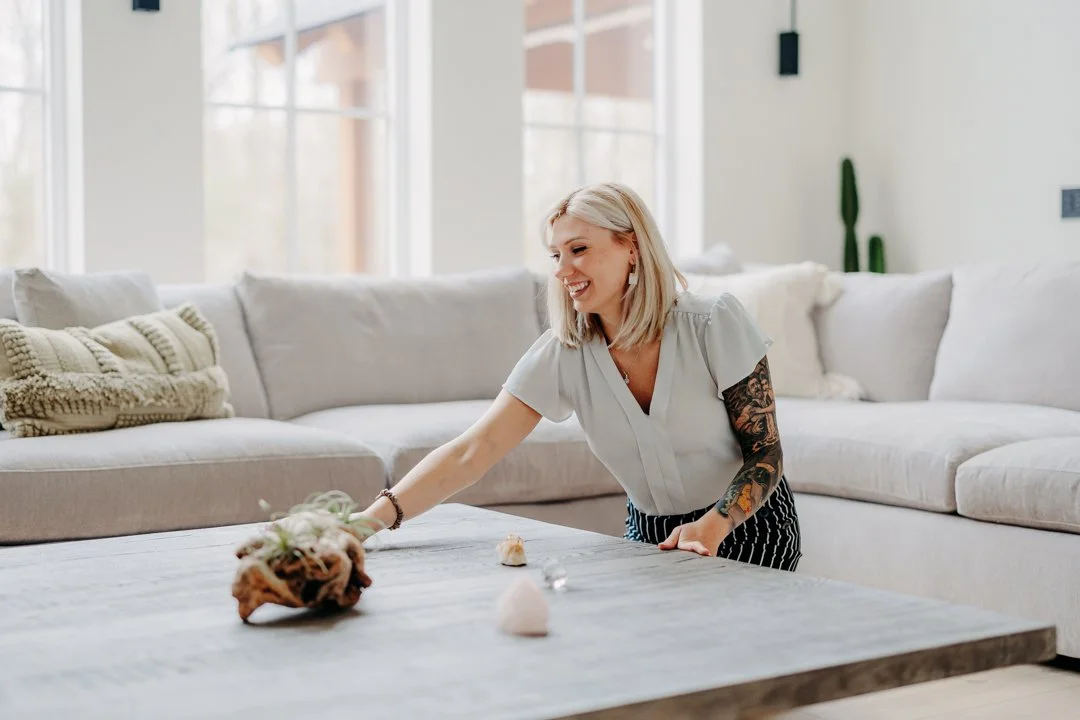Korinna a professional organizer in Massachusetts working in a client’s living room, arranging coffee table items and removing surface clutter during an organizing session.