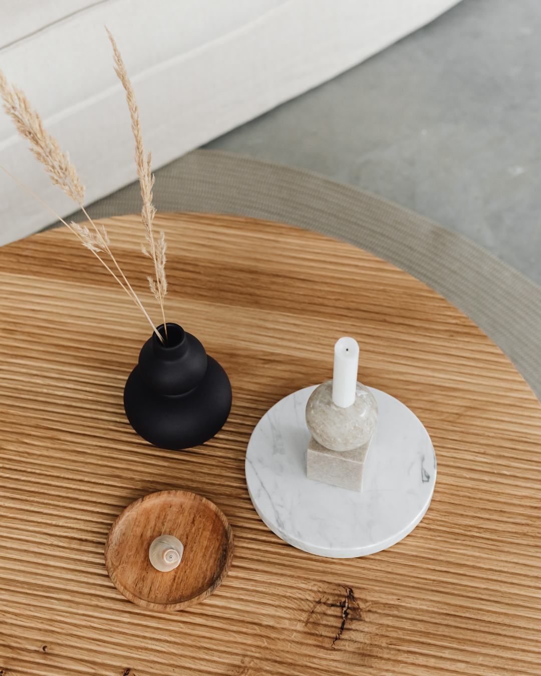 Coffee table styled with a book, candle, and tray after decluttering services removed excess items from the surface.