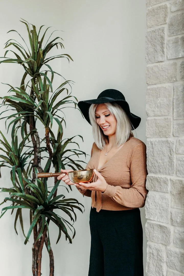 Korinna, a feng shui organizer in Massachusetts, holding a houseplant while working with natural elements to support balanced energy in the home