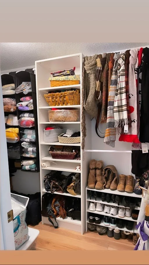 Closet with shelves of folded clothes, handbags, scarves, and shoes.