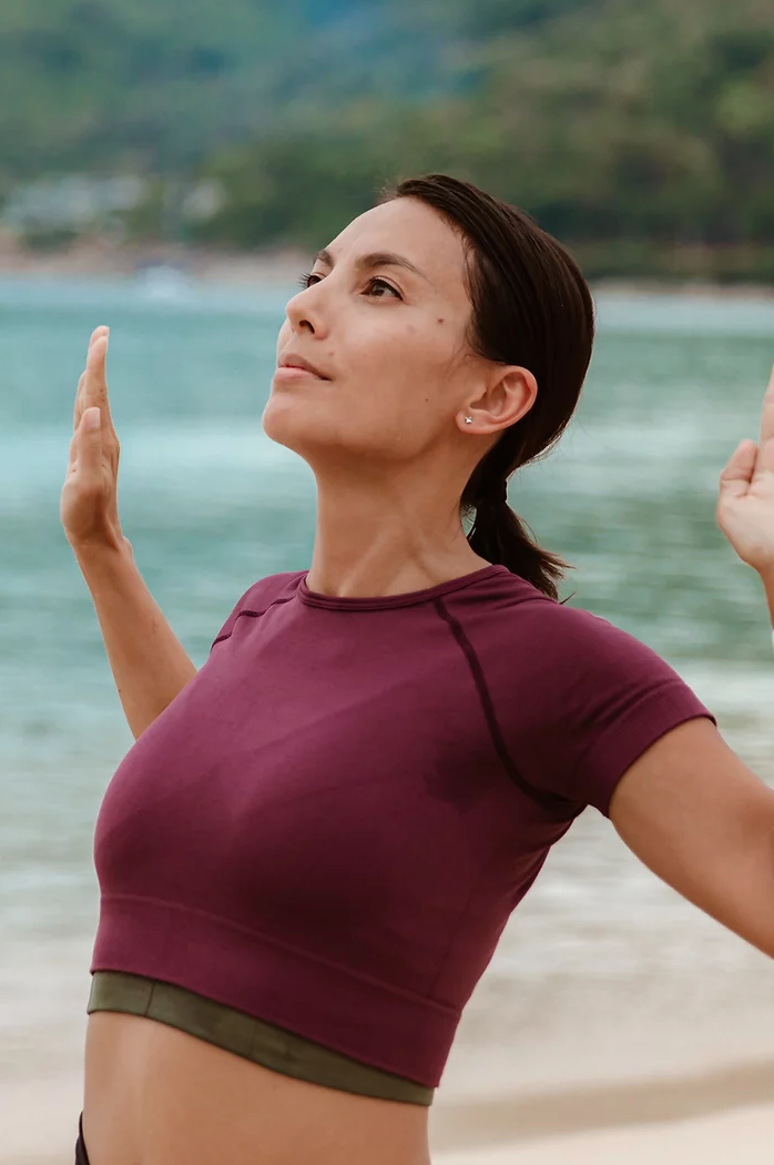 Person in exercise pose near the ocean.