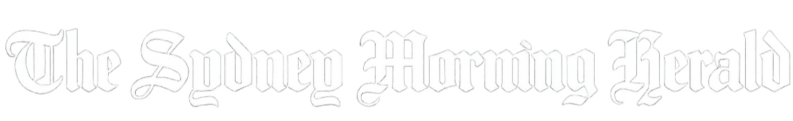 Two women in polka dot shirts sitting at a conference table, discussing documents and taking notes.