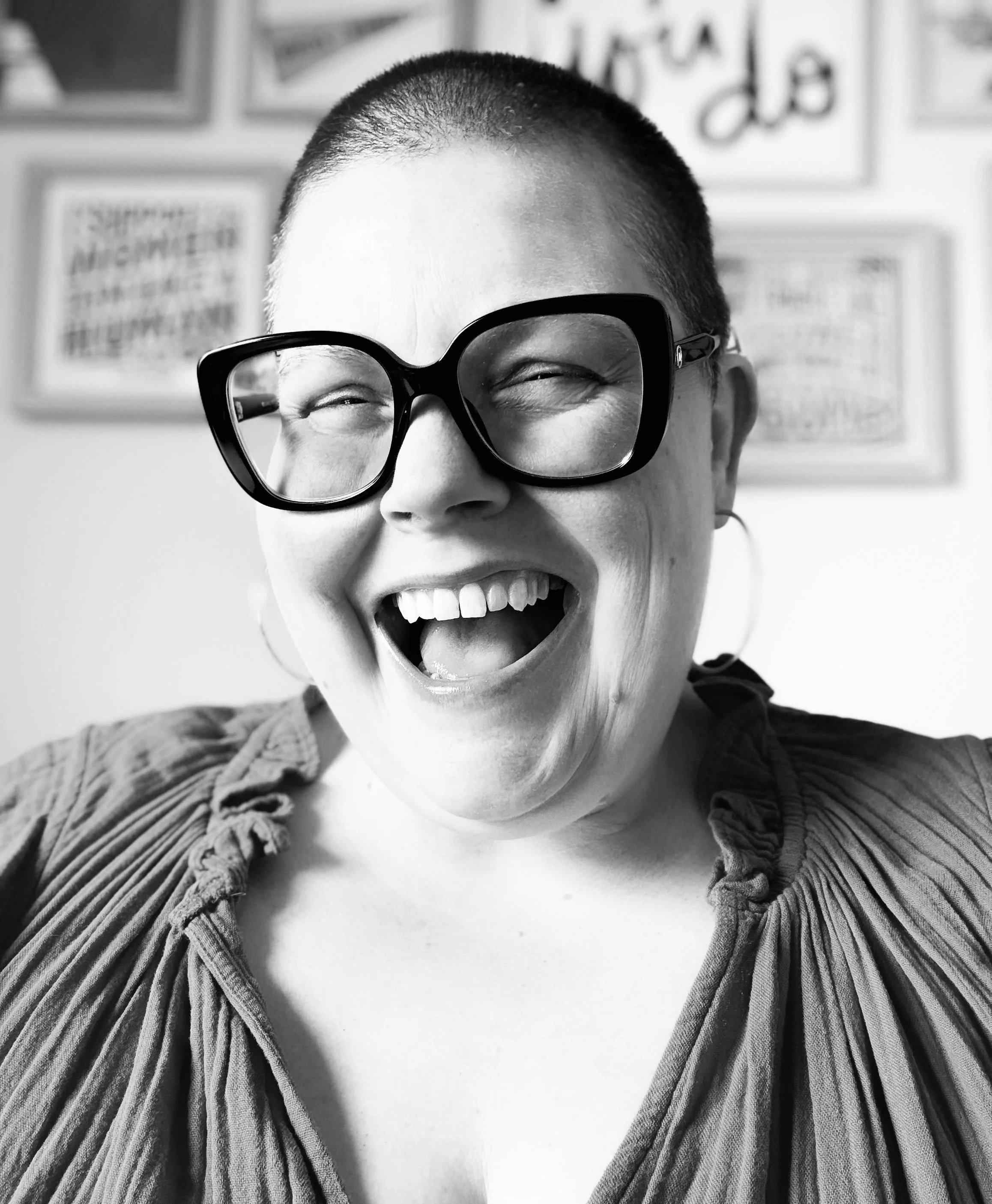 Black-and-white portrait of the Karen Hammons Co. founder smiling in oversized glasses.