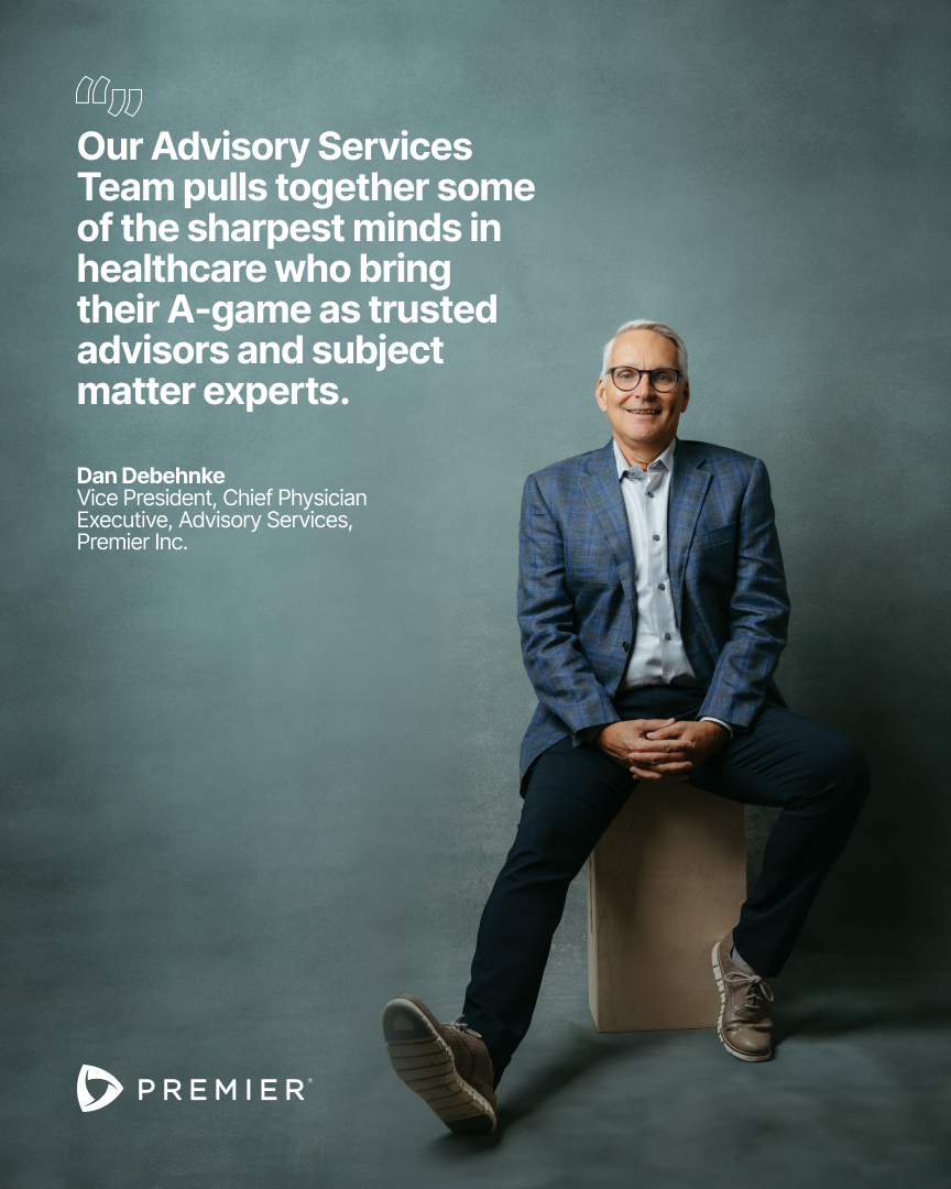 A man in a blue plaid blazer, white shirt, and dark pants sitting on a wooden block against a gray background, smiling at the camera. Text on the image highlights Premier Inc.'s advisory services and features Dan Debohnke, Vice President and Chief Ph