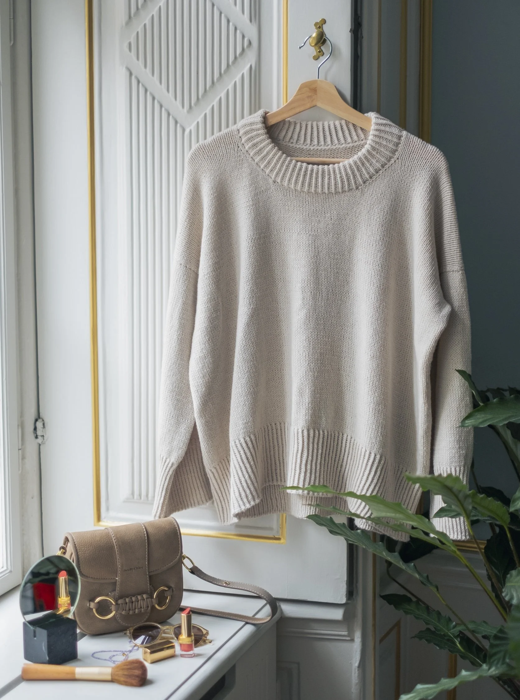 Cream-colored Simple Things Sweater, a relaxed and oversized design, displayed on a hanger.