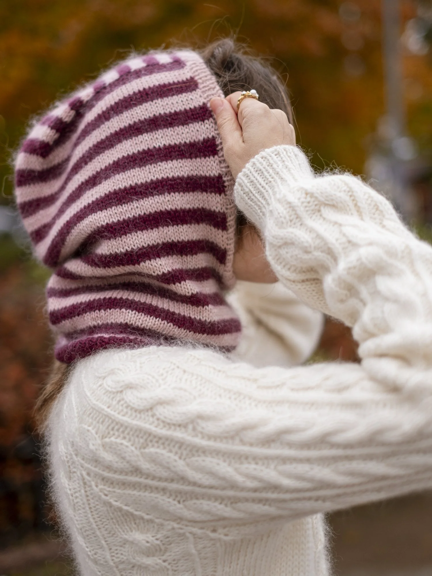 in-my-stripes-era-balaclava-pulling-on-striped-knit-hood-outdoors.jpg