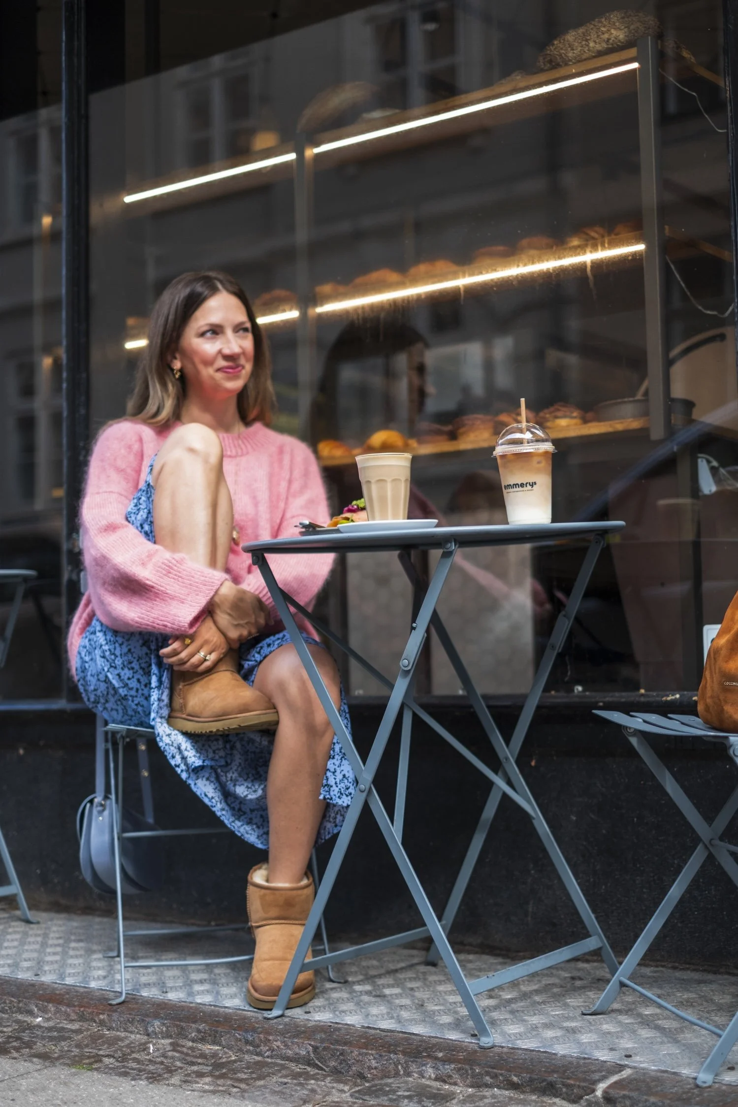 Kika sitting on a terrace wearing a relaxed and oversized simple things sweater made with silk mohair.