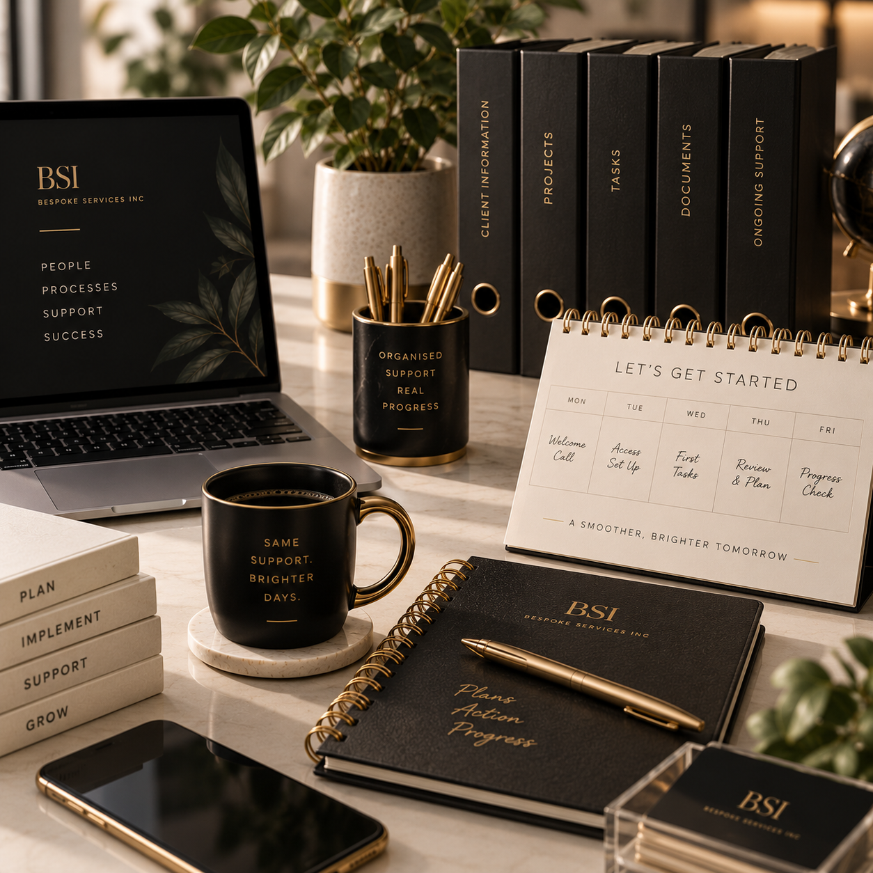 A well-organized office desk with a laptop, black and gold coffee mug, notebook, planner, stacked books, binders, pen holder, a weekly planner, and a potted plant.