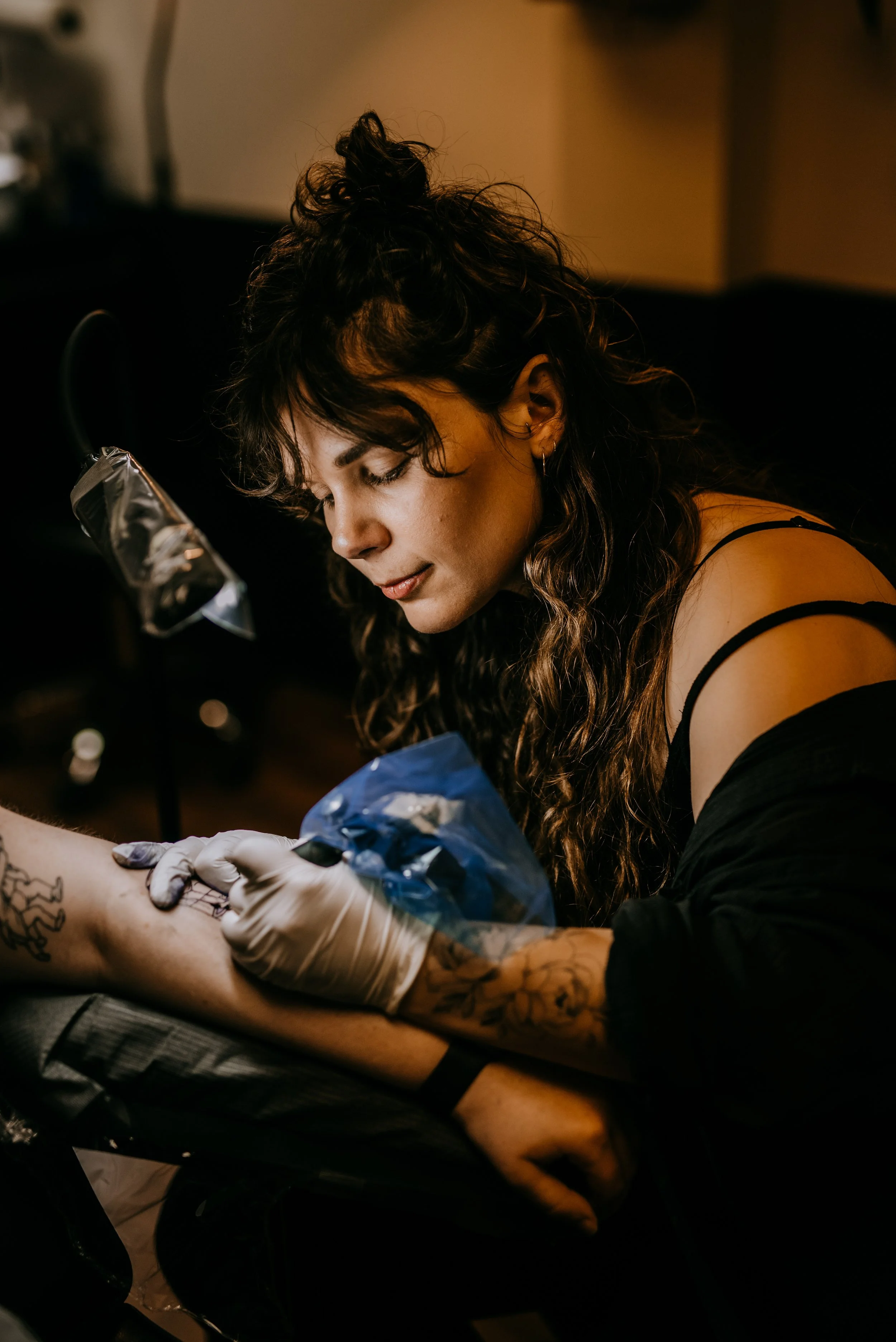 Tattoo artist Jill (@jdawn.tattoo) tattooing a client at Black Eleven Tattoo in Halifax.