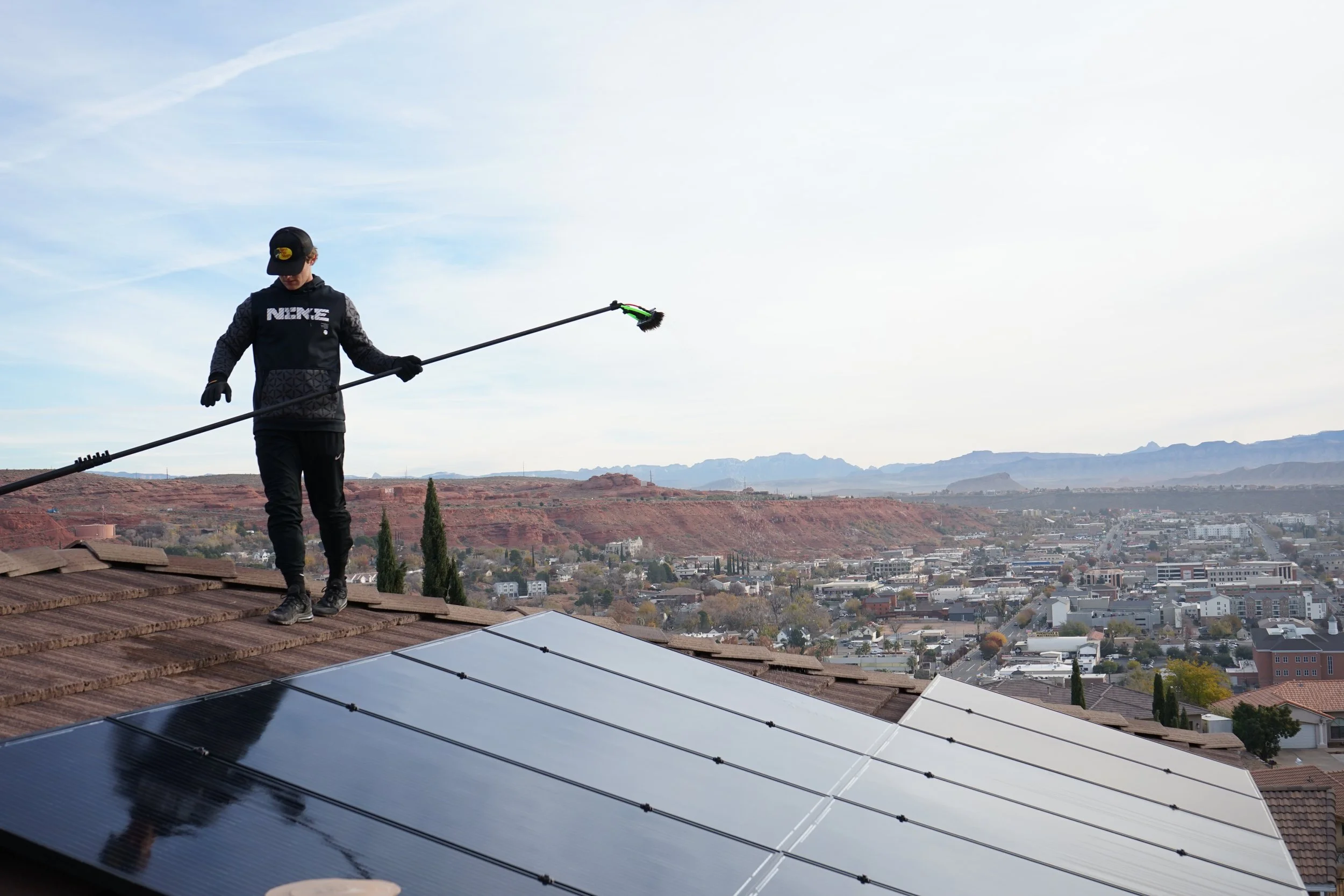 3SIXTY tech standing on top of a roof after cleaning solar panels.