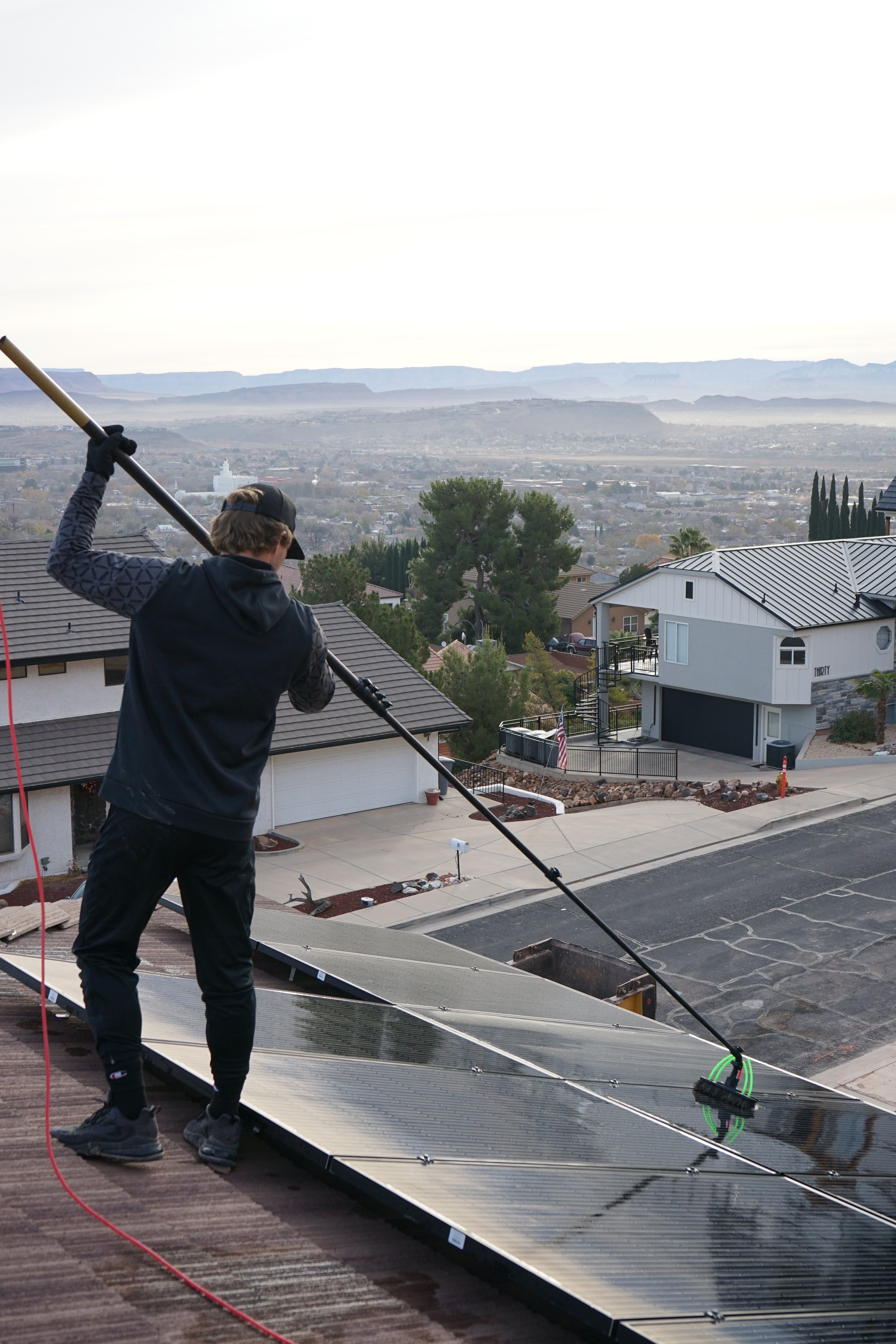Picture behind our tech cleaning solar panels with a brush.