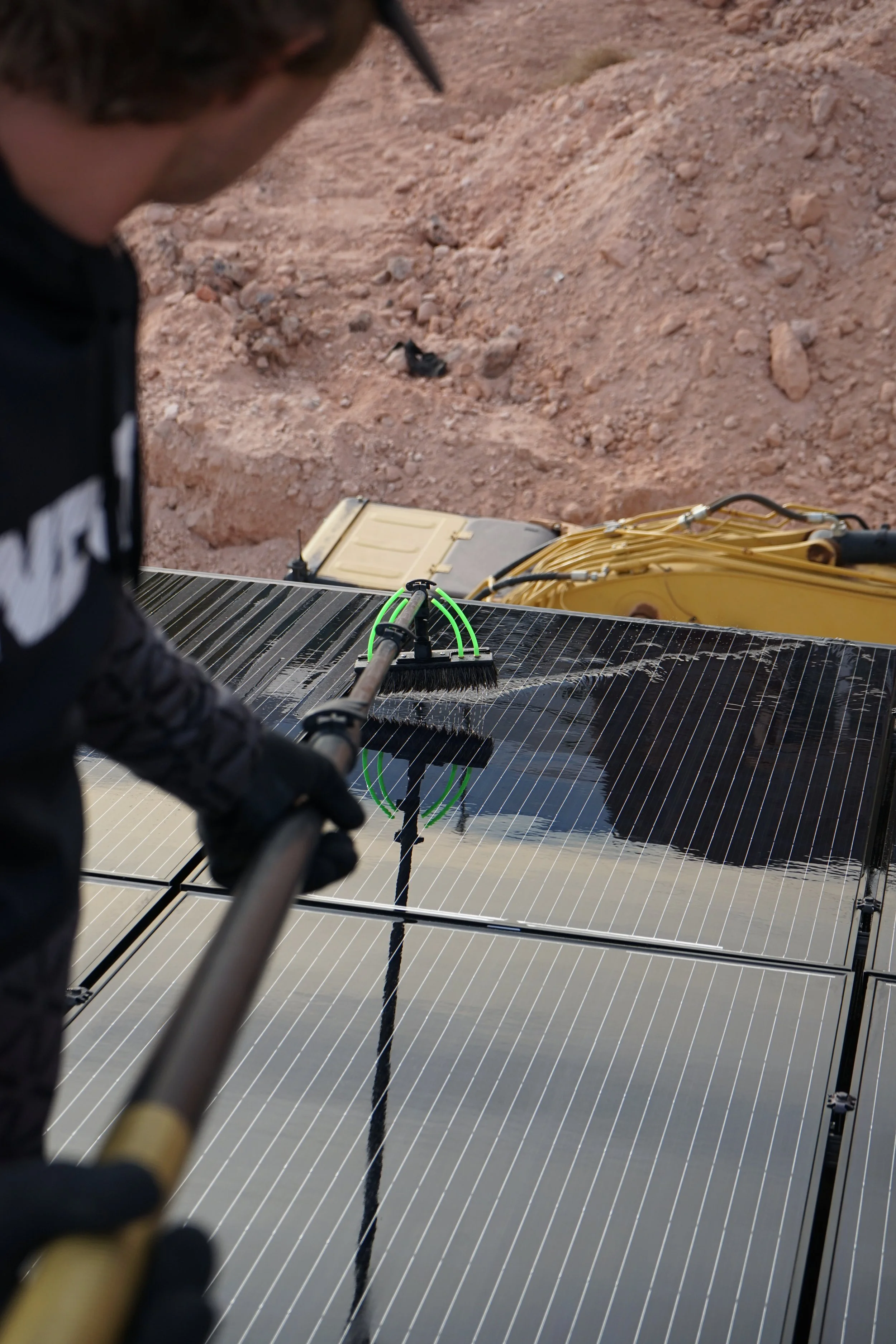 Picture over the shoulder of 3SIXTY Window Washing tech cleaning solar panels in St. George Utah.