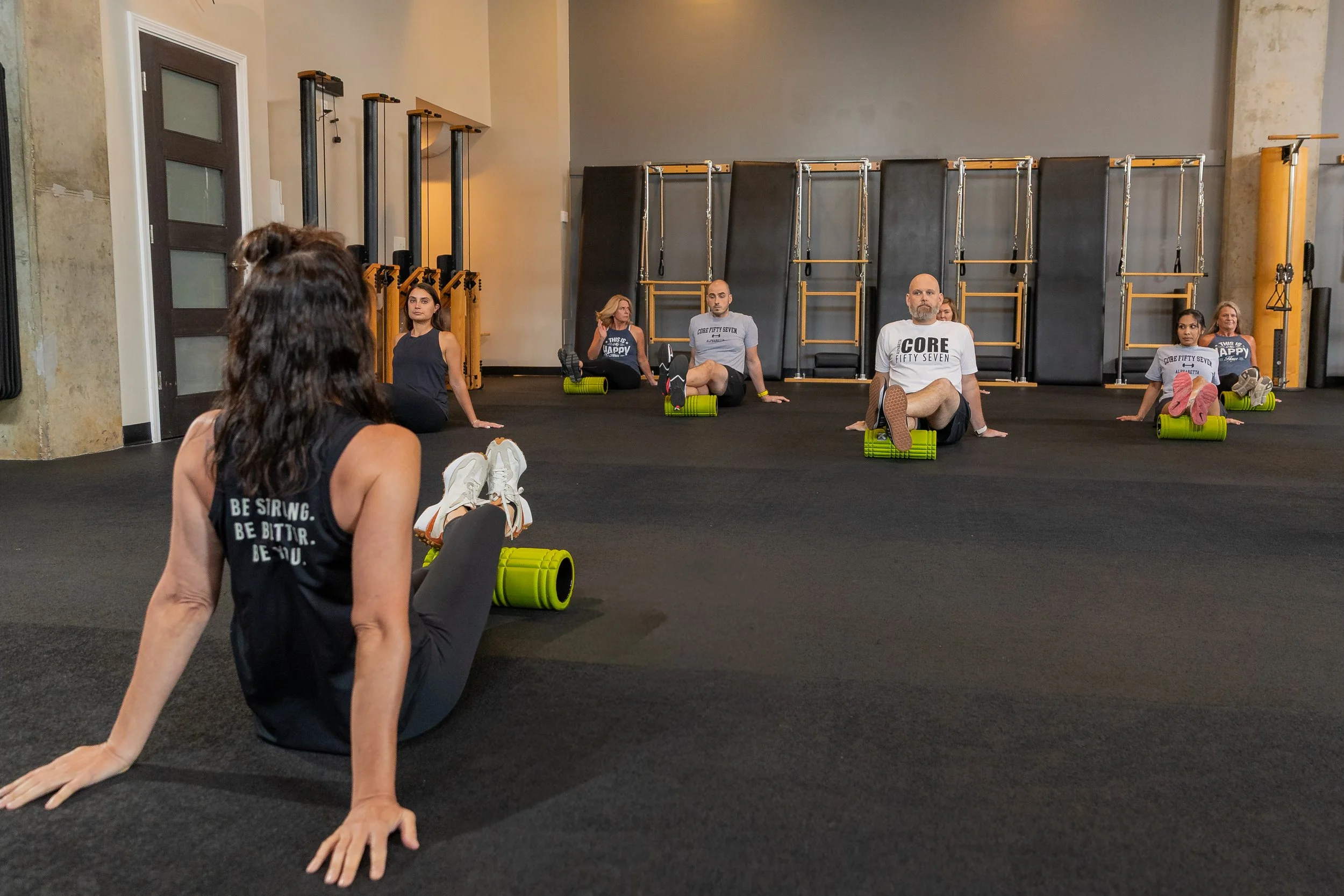 Clients using TriggerPoint grid rollers to release tight calf muscles during a recovery class at CORE57 in Alpharetta