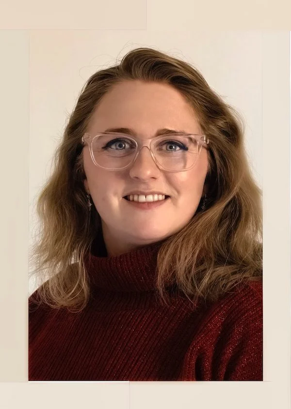 Alysha Plaggemeier wearing red turtleneck knit sweater smiling at the camera