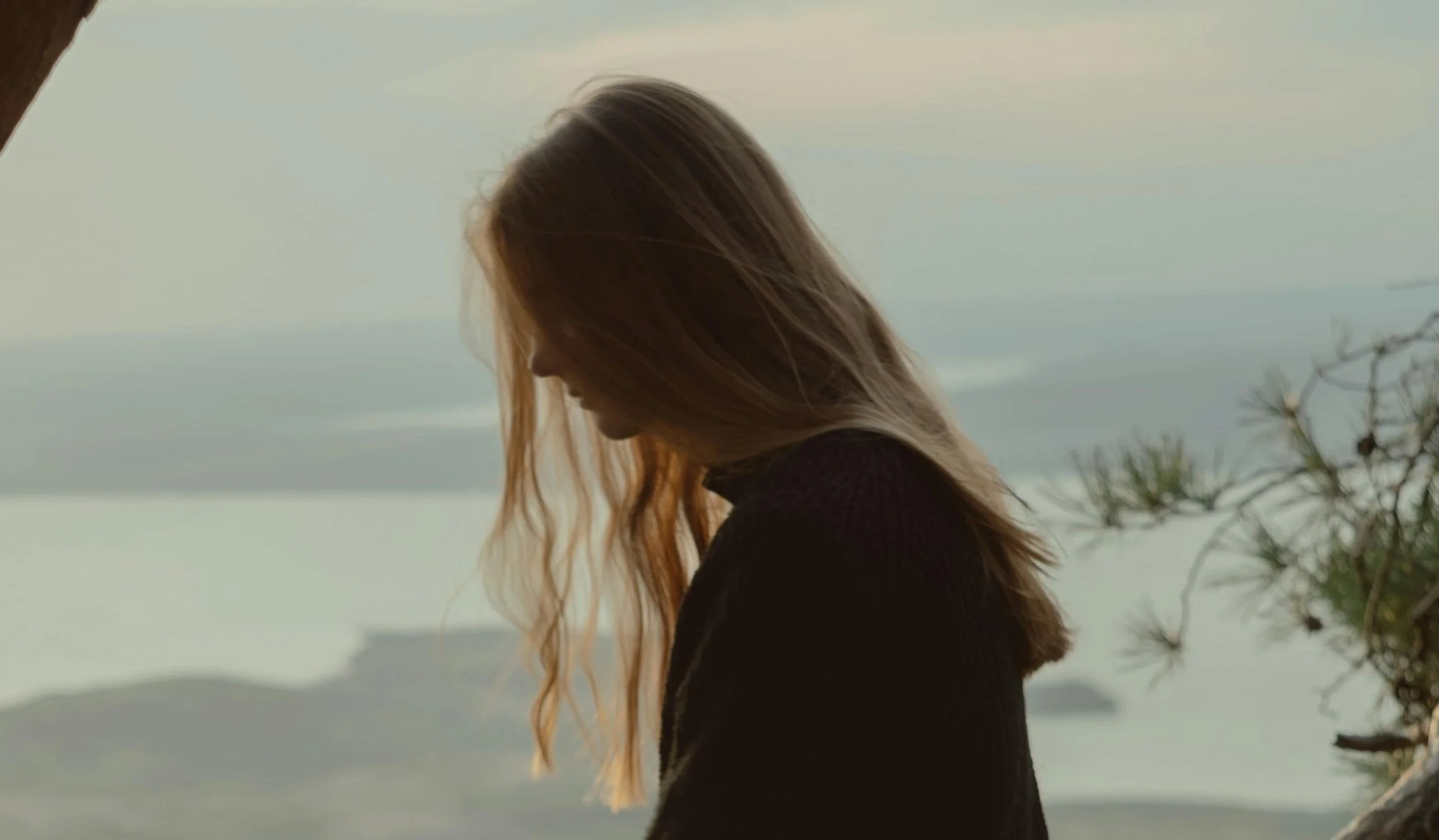 girl sitting on tree and looking into distance